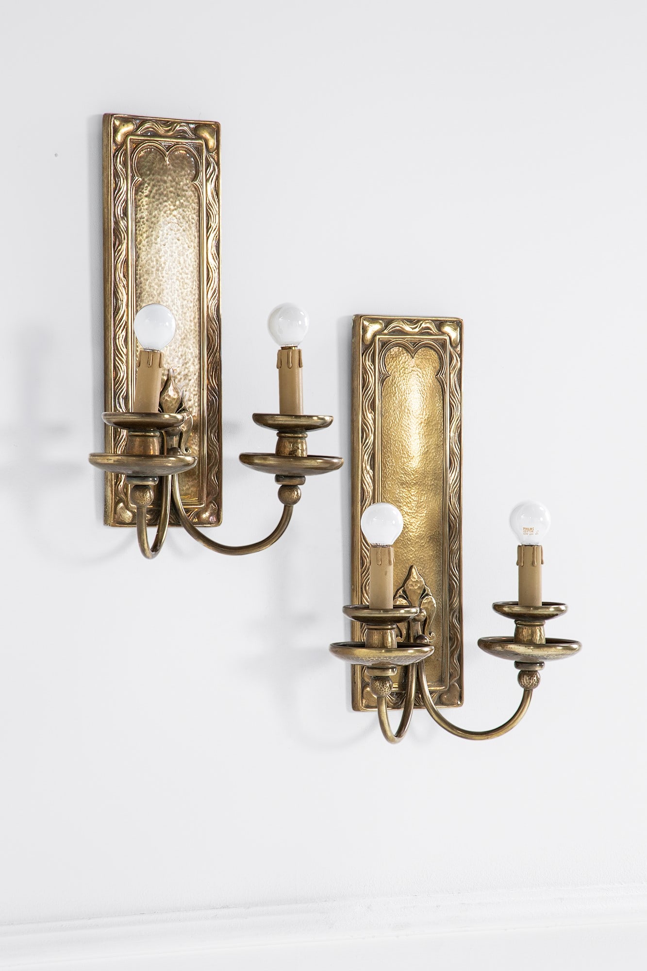 Due lampade da parete Art Nouveau: Due lampade da parete Art Nouveau Fusione di bronzo con decoro stilizzato vegetale. 1910-1920 cm 46x32x16