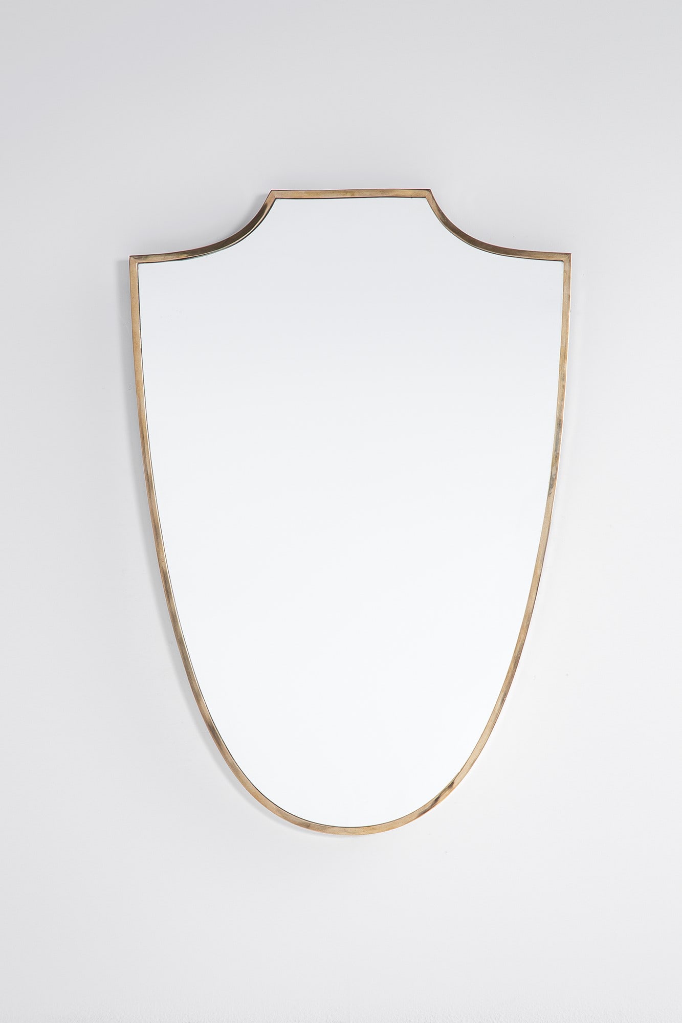 Specchio da parete a scudo: Specchio da parete a scudo Ottone lucido, vetro specchiato. 1950 ca. cm 78x54x3