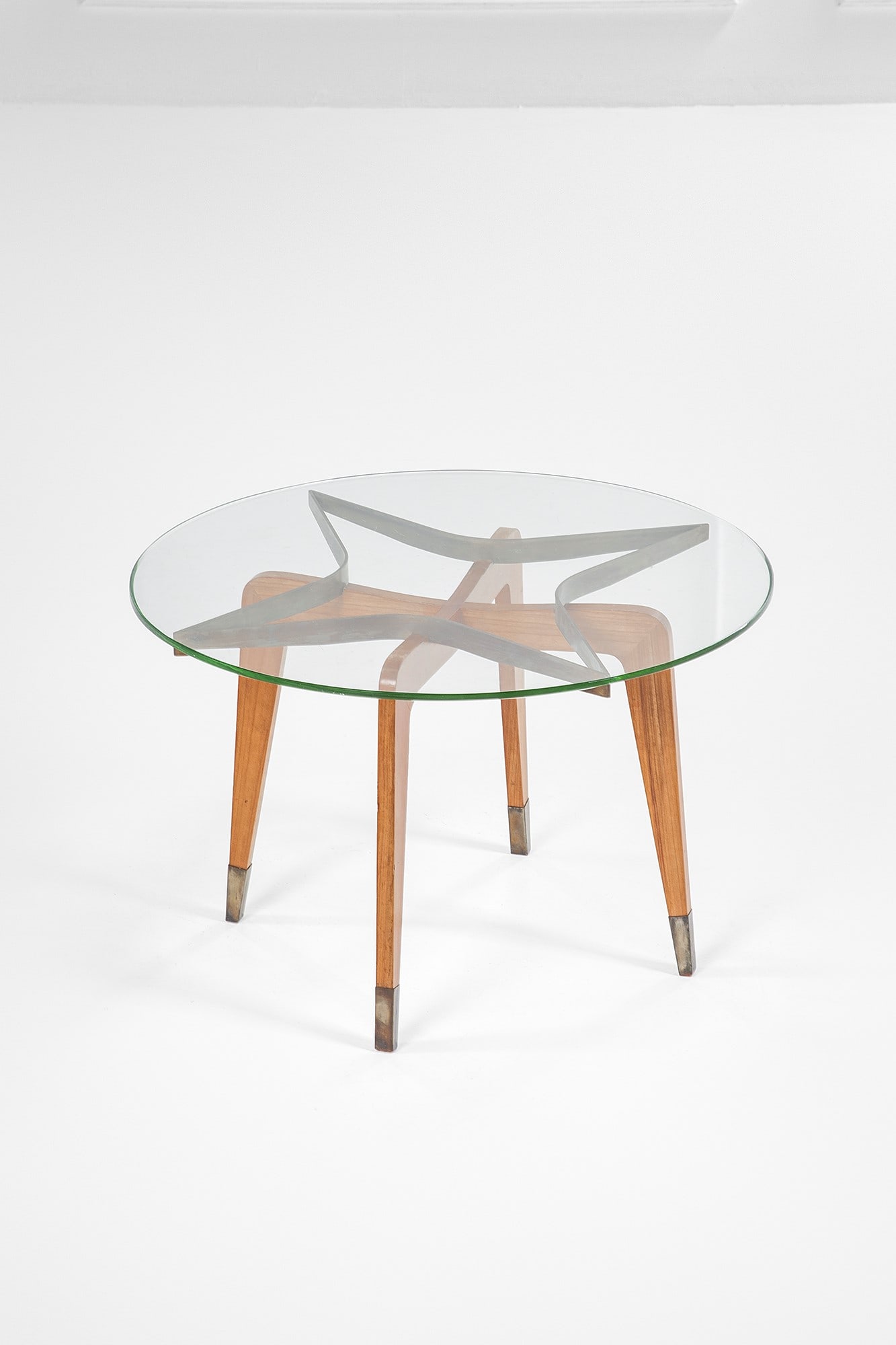 Gio Ponti, nel gusto di. Tavolino: Tavolino Legno massello sagomato, ottone, cristallo molato. 1950 ca. h cm 47, diam. cm 53