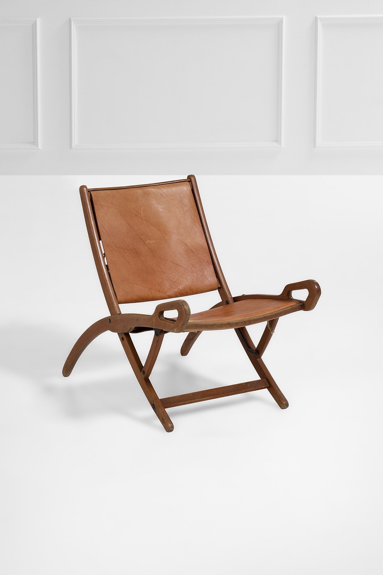 Gio Ponti. Poltrona pieghevole mod. Ninfea: Poltrona pieghevole mod. Ninfea Legno tinto, ottone, cuoio. Prod. Fratelli Reguitti, anni '50 Marchio del produttore. cm 71x80x53 Literature: Domus, n. 348, novembre 1958, p. pubblicitaria.