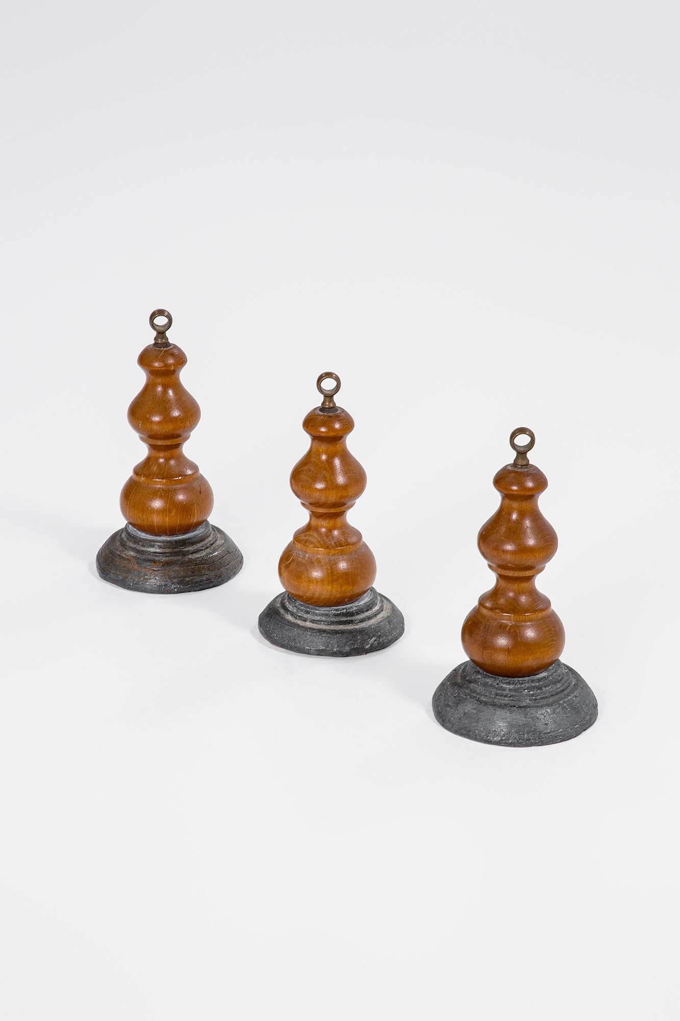 Tre fermaporta: Tre fermaporta Legno tornito, pietra, ottone. 1960 ca. h cm 19, diam. cm 10