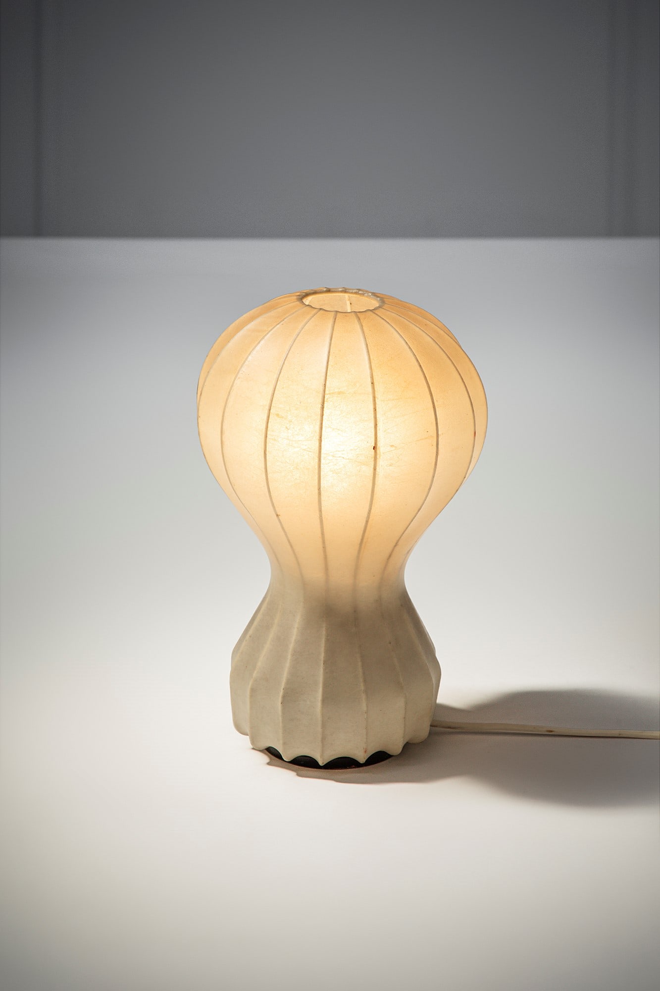 Achille e Pier Giacomo Castiglioni. Lampada da tavolo mod. Gatto: Lampada da tavolo mod. Gatto Cocoon, metallo verniciato, legno. Prod. Flos, 1962 ca. Etichetta del produttore. h cm 31, diam. cm 18