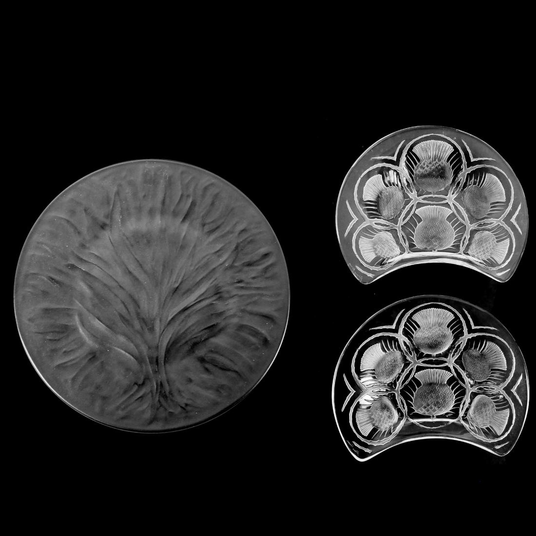 Lalique Plates: Lalique "Algues Noir" Glass Dinner Plate along with a Pair of Lalique "Chardon" Crystal Desert Plates. Each appropriately signed. Lalique plate measures 11-1/8". Pair of plates measure 1-1/8" x 8" x 6
