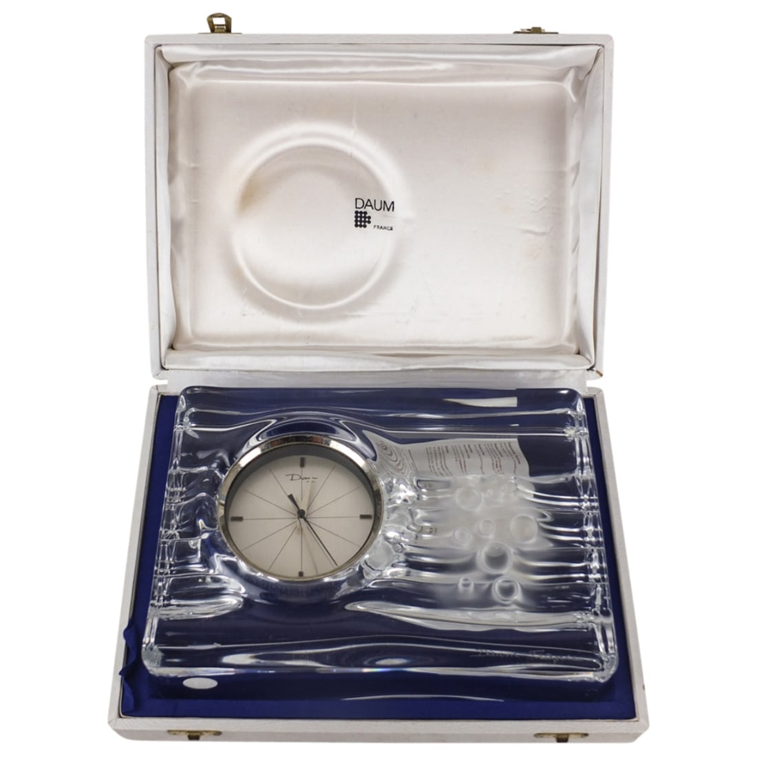 Daum France Mantel Clock: Large Daum France Glass Mantel Clock in Original Box. signed. Measures 7-1/4" x 10-1/4" x 2-3/4". Box measures 3-1/4" x 12" x 9". Condition: Has a bruise to the body. Estimate 100 - 300 Domestic shipp