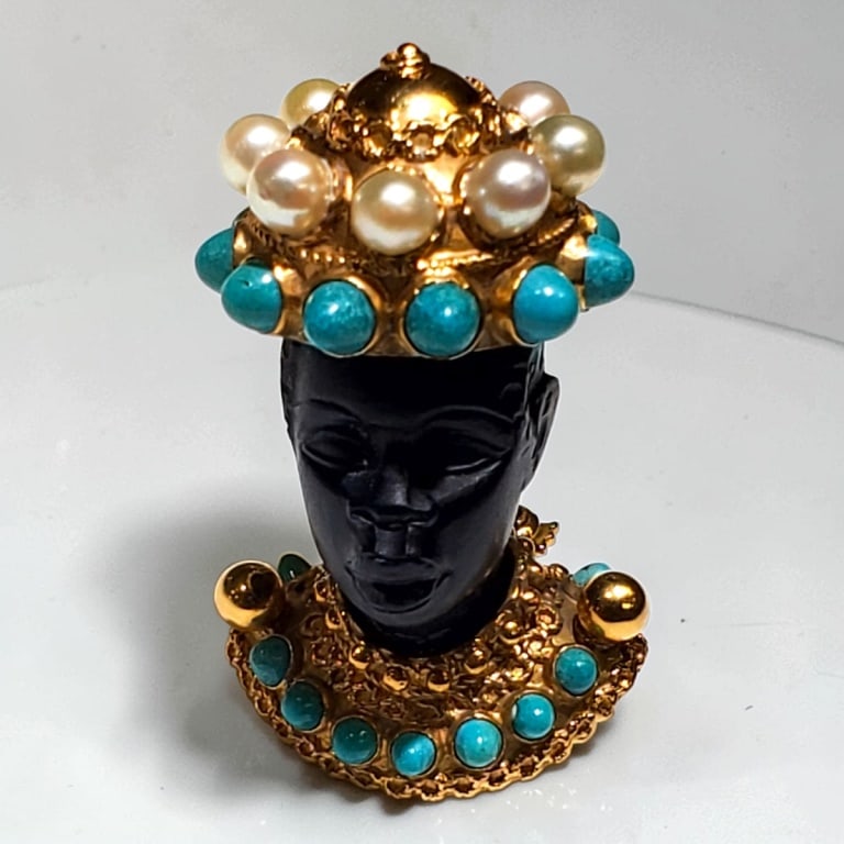 Vintage 18K Blackamoor Pin / Brooch: Vintage 18 Karat Yellow Gold Blackamoor Pin / Brooch with Pearl and Turquoise Embellishments. Stamped. Measures 1-3/4" 1". Approx. weight: 21.8 grams. Condition: Good condition. Estimate 1500 - 2500