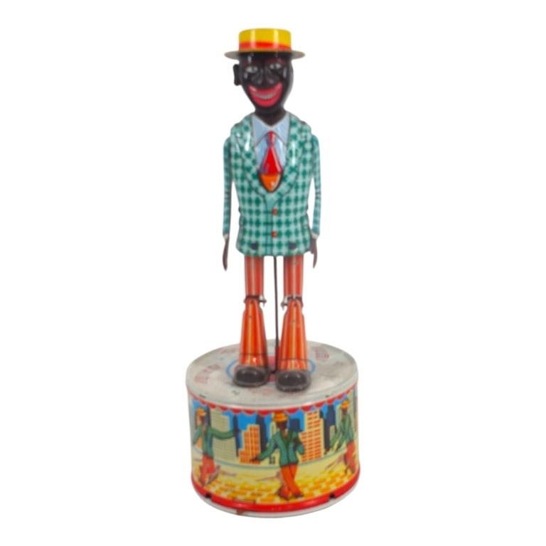 Black Americana Strutting Sam Toy: Black Americana Battery Operated Strutting Sam Tin Toy. Made in Japan. Measures 10-3/4" x 3-3/4". Please note that the working condition of the mechanical components of this lot is not guaranteed. Con