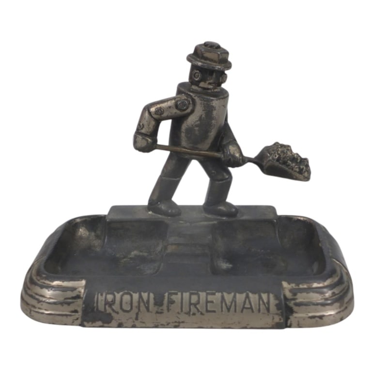 1930's Iron Fireman Ashtray: 1930's Iron Fireman Cast Metal Ashtray. Stamped A.C. Rehberger Co. Chicago. Measures 4-1/2" x 6-1/2" x 4-1/2" Condition: Condition consistent with age and use. Estimate 60 - 100 Domestic shipping