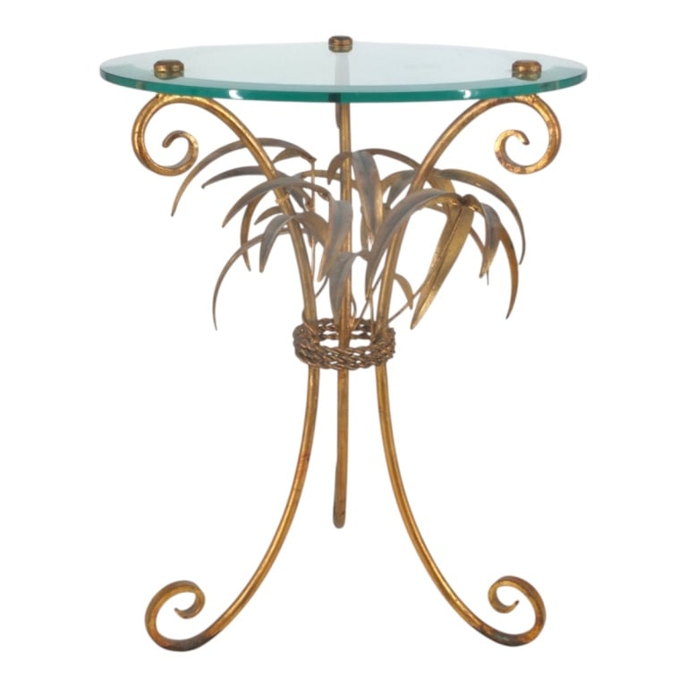 Vintage Hollywood Regency Gilt Tole Accent Table: Vintage Italian Hollywood Regency Gilt Tole Sculptural Accent Table. Featuring a spray of palm leaves under a beveled glass top. Unsigned. Measures 21" H x 17" diameter. Condition: Some bruising to th