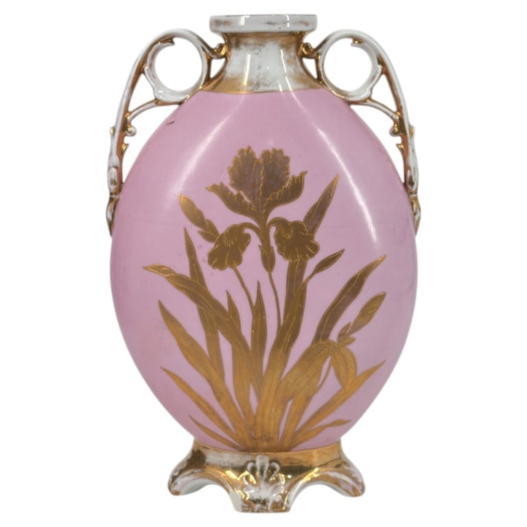 Antique Victoria Carlsbad Austria Porcelain Vase: Antique Victoria Carlsbad Austria Porcelain Vase. Decorated in a floral motif in gold on pink ground. Gilt handles, rim and base. Signed with blue backstamp on bottom. Measures 12-3/4" x 9" W x 4".