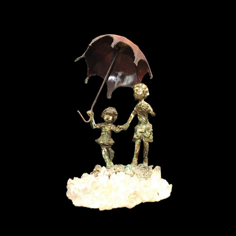 Mid Century Gilt Bronze and Quartz Specimen Group: Mid Century Gilt Bronze Miniature Figural Group Presented on a Quartz Specimen Base. Depicts young children walking in the rain. Overall measures 5-1/4" x 3-1/4" x 4-1/2". Condition: Good condition.