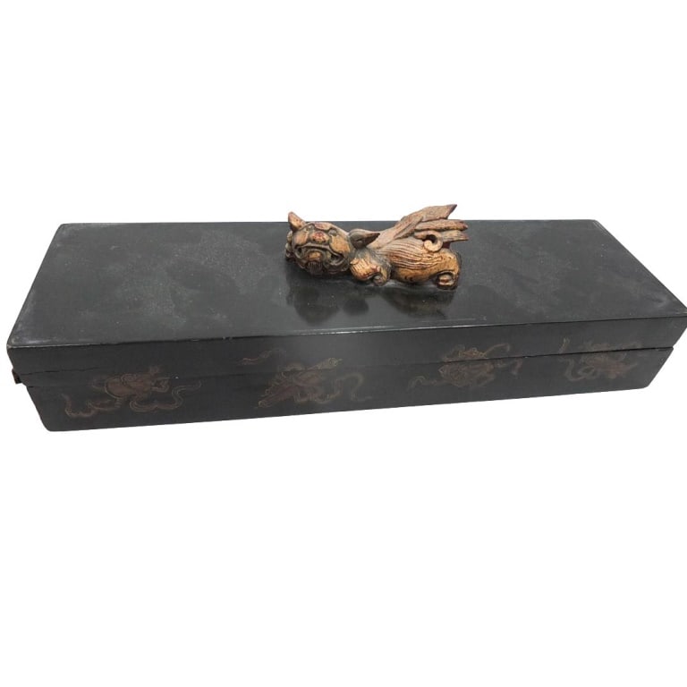 Mid-Century Chinese Covered Box: Mid-Century Chinese Black Lacquered Covered Box with Foo Dog Finial. Measures 4" x 14-5/8" x 4-1/2". Condition: Seam split encircling the apron of the cover. Estimate 100 - 300 Domestic shipping