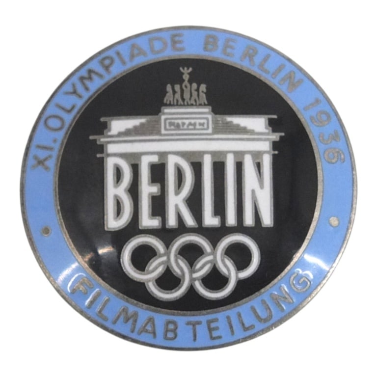 German WWII 1936 Berlin Summer Olympics Badge: German WWII 1936 Berlin Summer Olympics Filmmaker Badge. Marked Rob. Neff Berlin W57 on the reverse side. Measures 1-7/8" diam. Please be advised: This item has not been authenticated by an
