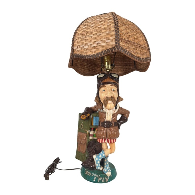 1970's Juta Sangthaweep Pilot Figurine as Lamp: 1970's Juta Sangthaweep Chalkware Pilot "Why Yes! I Fly" Figurine as Lamp. Vintage woven shade. Artist signed. Measures 27-1/4" H overall. The figure measures 18" to socket x 9-1/2" W x 6-1/2". Shade