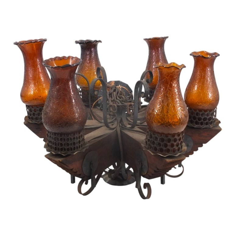 Early 20th C. Spanish Revival Chandelier: Early 20th century Spanish revival carved wooden 6 arm chandelier with iron mounts. Measures 17-1/4" x 24". Condition: Normal rubbing to the iron, scuffs to the wood. Estimate 100 - 300 Domestic
