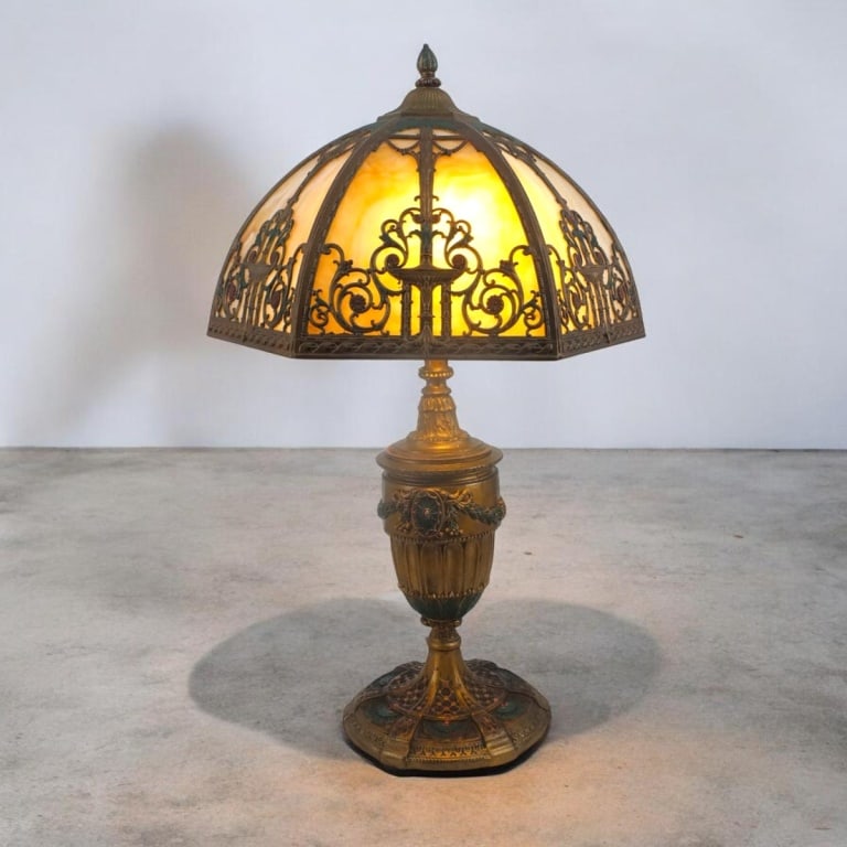 Bradley & Hubbard Arts & Crafts Slag Glass Lamp: Bradley & Hubbard Arts & Crafts Curved Slag Glass Lamp. c. 1920's Enameled Brass shade and base. No visible signature. Measures 27" H overall, shade measures 9" H x 17" W. Condition: No chips or