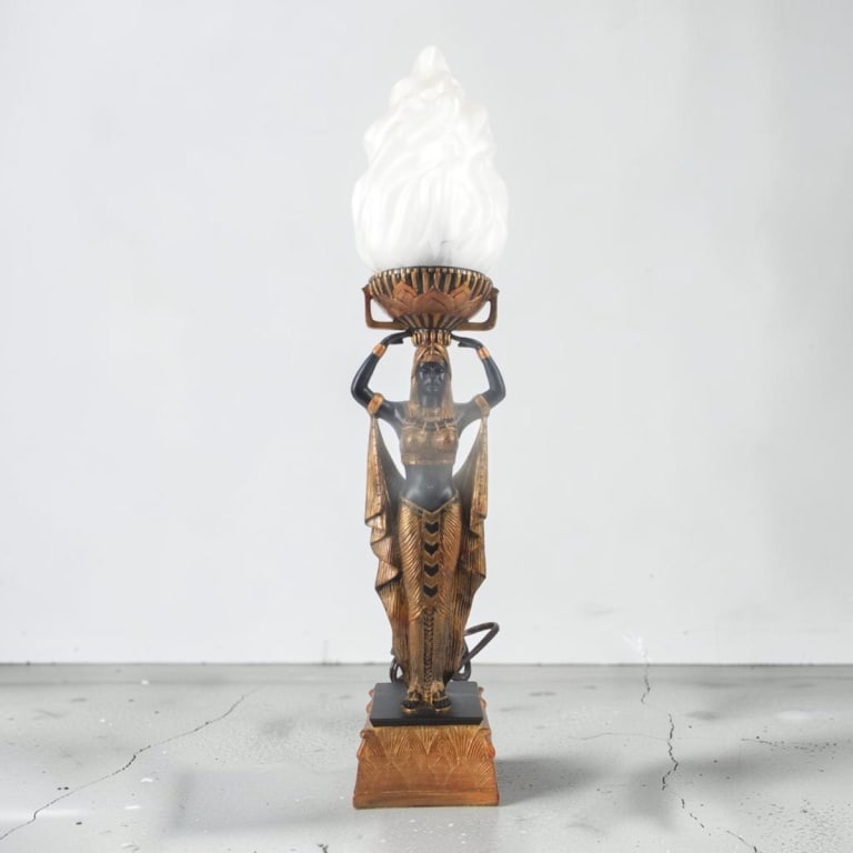Art Deco Style "Nubian Queen" Figural Torch Lamp: Art Deco Style "Nubian Queen" Figural Torch Lamp. Hand finished composition base with glass "torch" shade. Unsigned. Measures 22" H. Condition: Good condition. Estimate 100 - 300 Domestic shipping