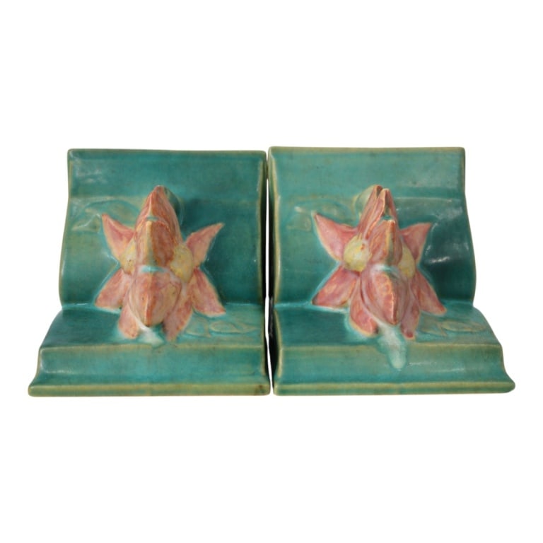 Pair of Roseville Bookends: Pair of Roseville Zephyr" Pottery Bookends. Marked on the base. Measures 5-1/4" x 5-1/4" x 4-3/4". Condition: One bookend has a small nick to the flower. Estimate 100 - 300 Domestic shipping Third