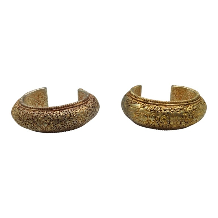 Pair Vintage Tibetan Gold-gilt Cuff Bracelets: Pair Vintage Tibetan Gold-gilt Cuff Bracelets. With intricate repousse decoration. Unsigned. Measures 2-1/4" opening. Condition: Light wear or in good condition. Estimate 100 - 200 Domestic shipping T