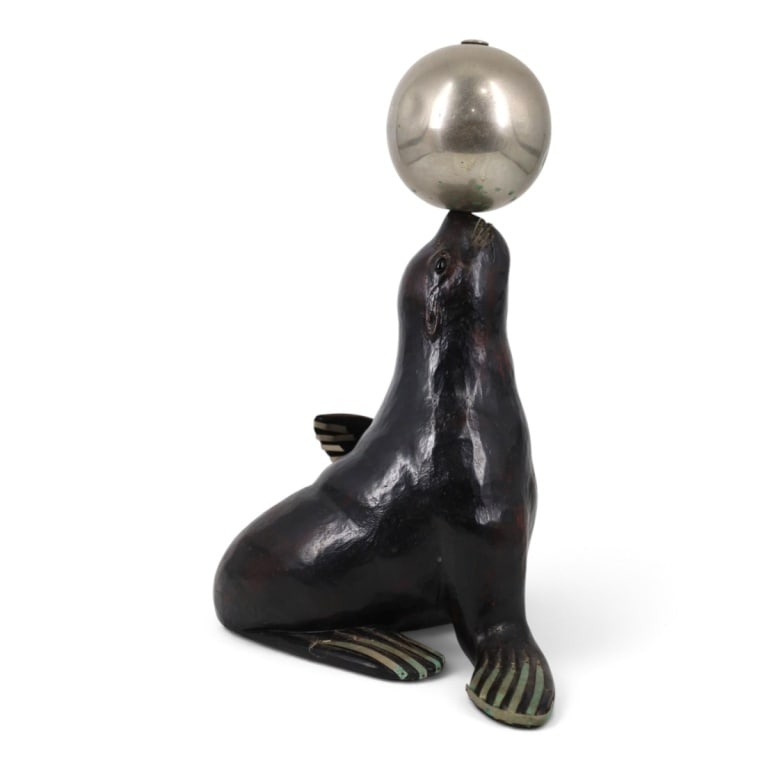 Art Deco Carved Wood, Metal Sea Lion Sculpture: Art Deco Carved Painted Wood, Metal Sea Lion Sculpture. Depicts the animal balancing a silver metal sphere with inlaid metal strips to flippers, whiskers and glass eyes. Unsigned. Measures 16-1/2" x