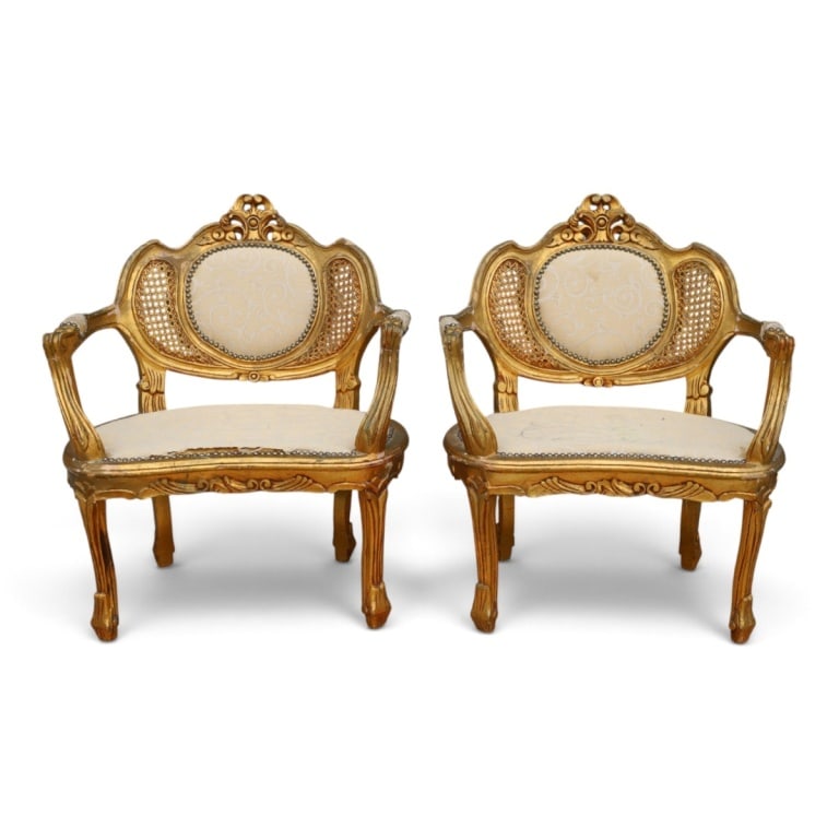 Pr Antique French Carved Rococo-Style Armchairs: Pair of antique upholstered giltwood and carved French Louis XV-style Armchairs. Unsigned. Measures 34" H x 28" W x 19" D. Condition: Wear, rubbing, losses, upholstery stained, wear. Condition consist