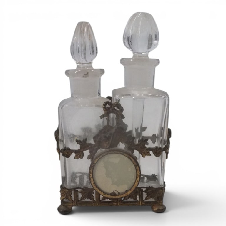 1930's Apollo Bronze & Crystal Scent Bottles Caddy: 1930's Apollo Studios Bronze & Crystal, Possibly Baccarat Scent Bottles in Caddy. Stamped Apollo 3611. Measures 5" H. Condition: 1 with chips on bottom, the other in good condition. Estimate 80 - 160 