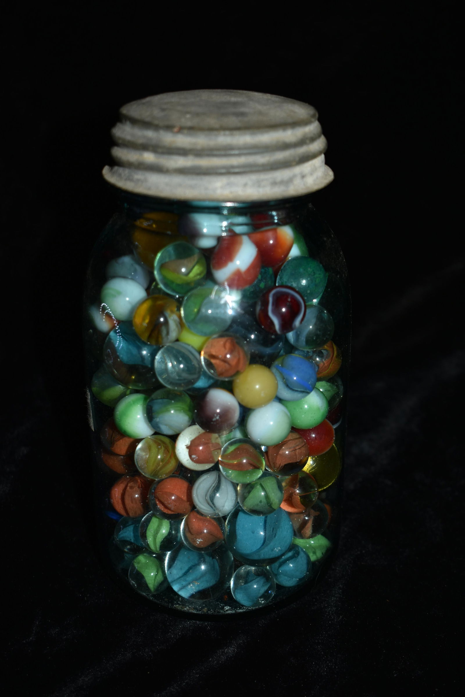 Mason Jar of Marbles: 1 Quart Ball Mason Jar full of Marbles. Most of the marbles are old ribbon marbles. Has 2 or 3 shooters in it. Sizes range from 5/8" to 1"