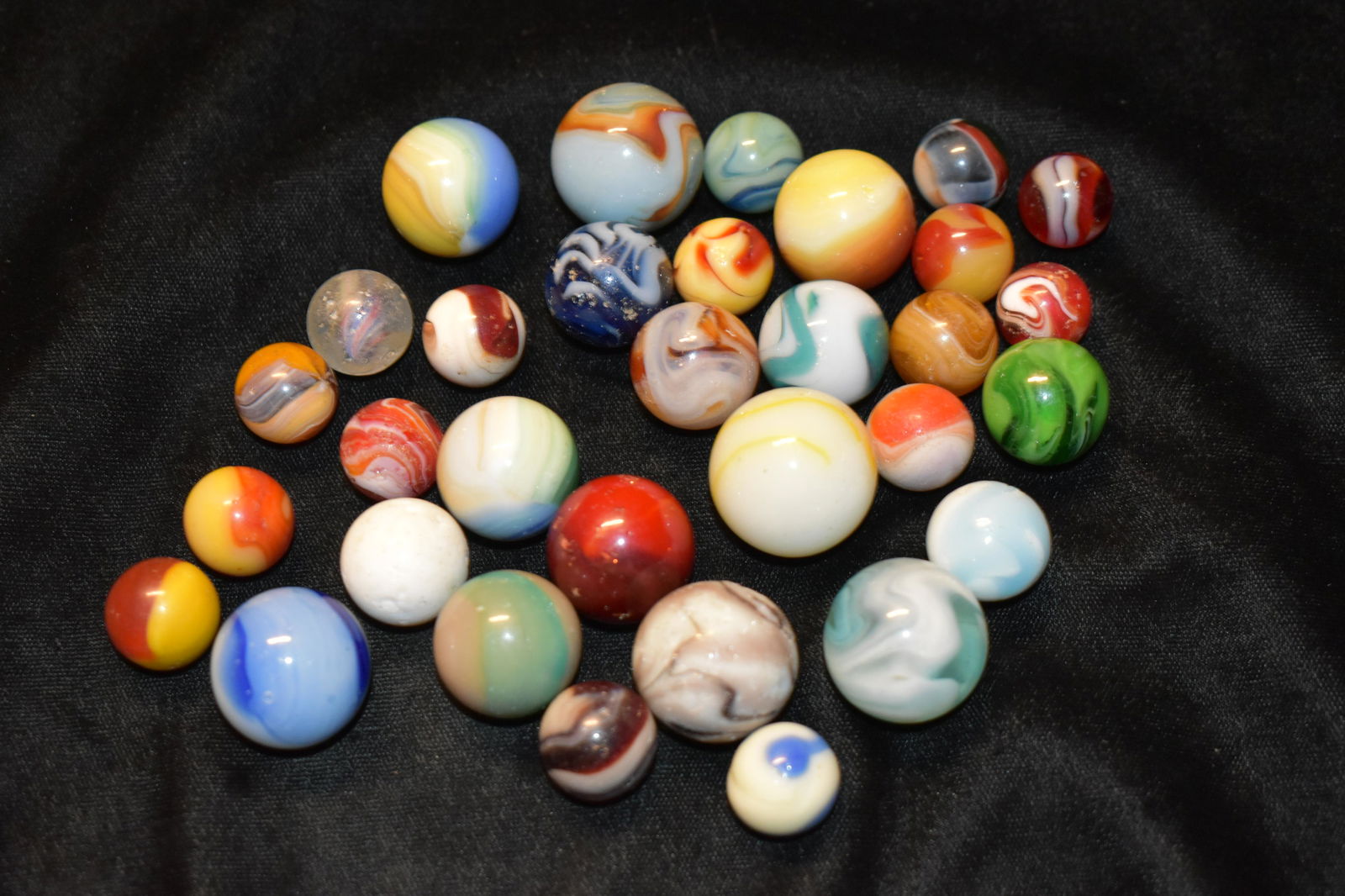 Over 30 Early to Mid-Century Marbles: This lot consists of over 30 marbles from the early to mid 1900's. There are several akro agates, tri-color Peltier, a couple alley and 1 German solid core marble. Back when these marbles were made ki