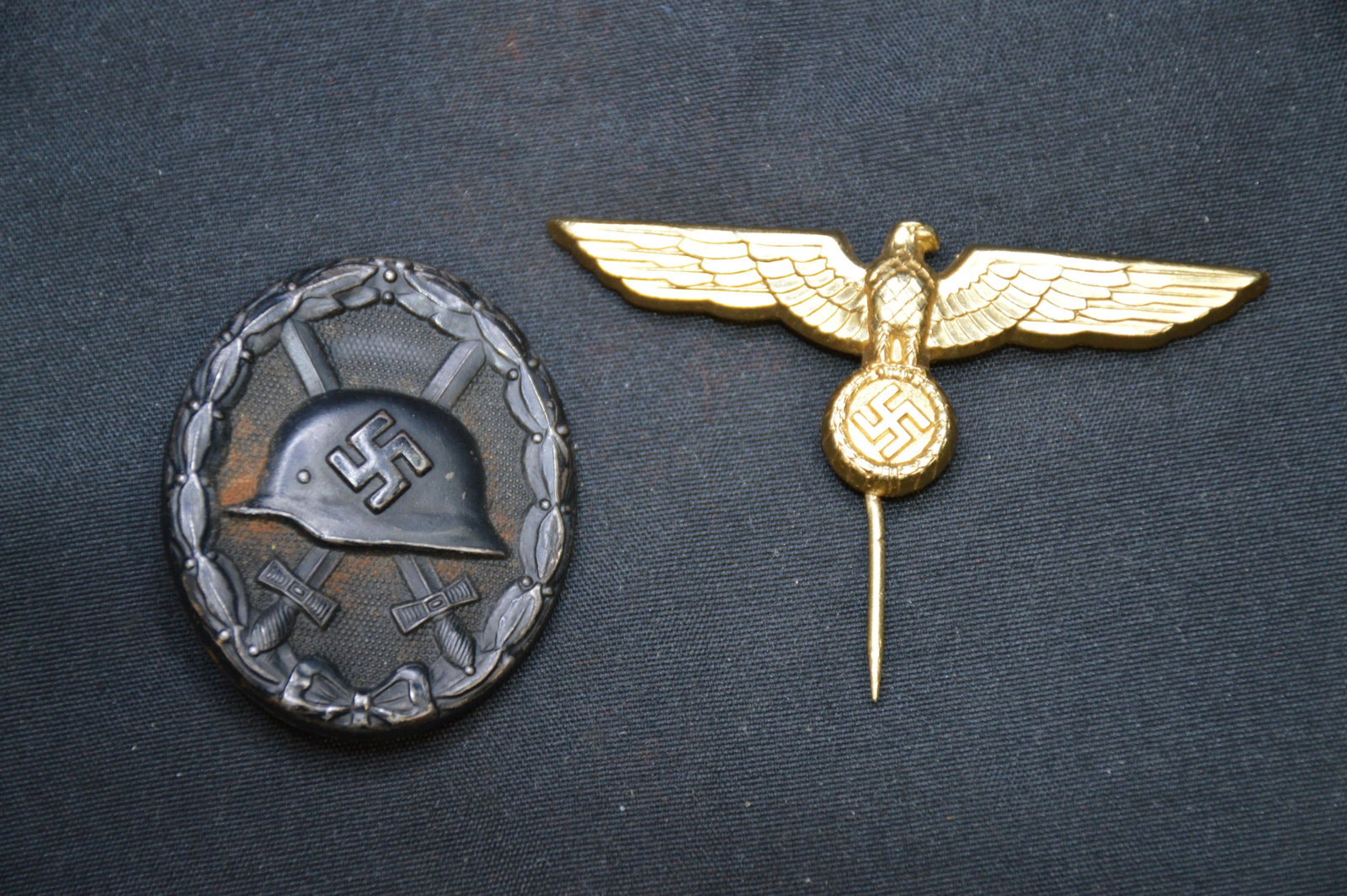 2 German Nazi Pins "Eagle may be Modern": With a Swastica on Helmet and 2 Swords crossed in a wreath. The Eagle could be modern. It's made from very light metal and Iâ€™m not sure the age of it.