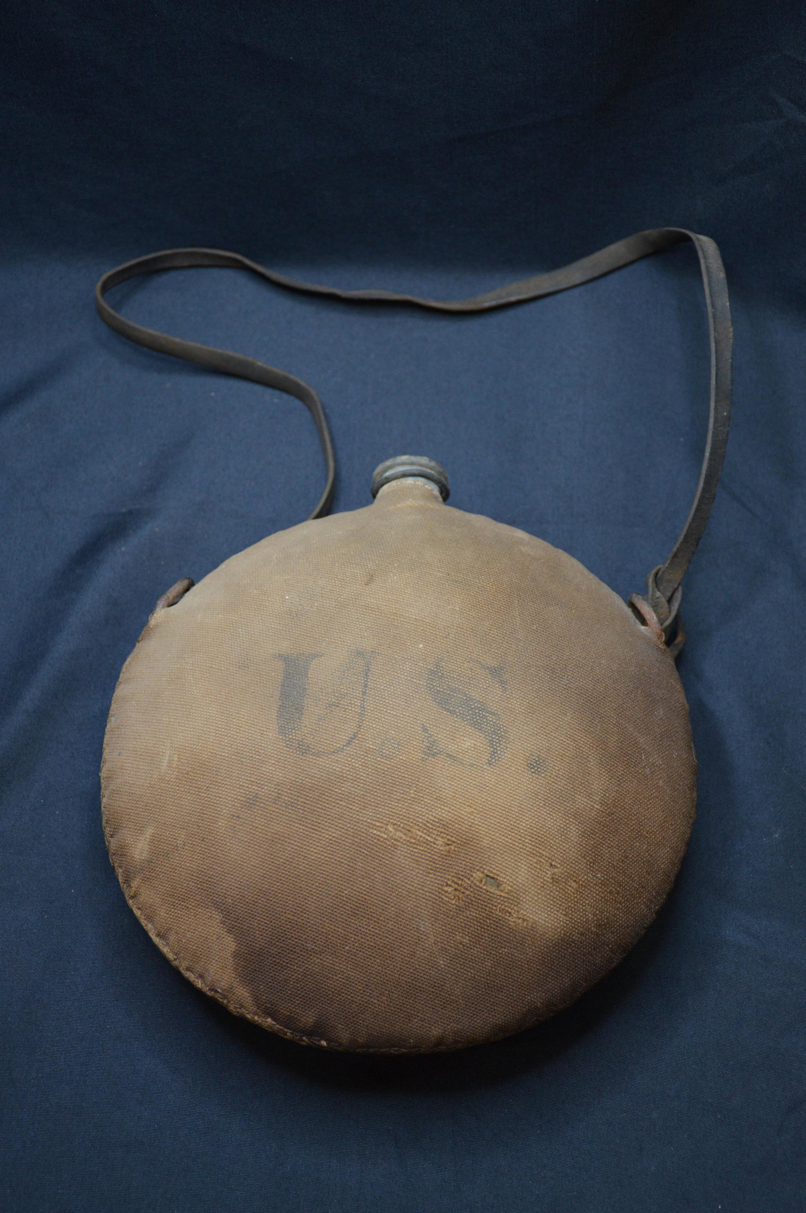 1800's U.S. Military Water Canteen: Has U.S. in the canvas cover with some wear from age, metal inside and the leather strap is in great shape. Missing the cap.