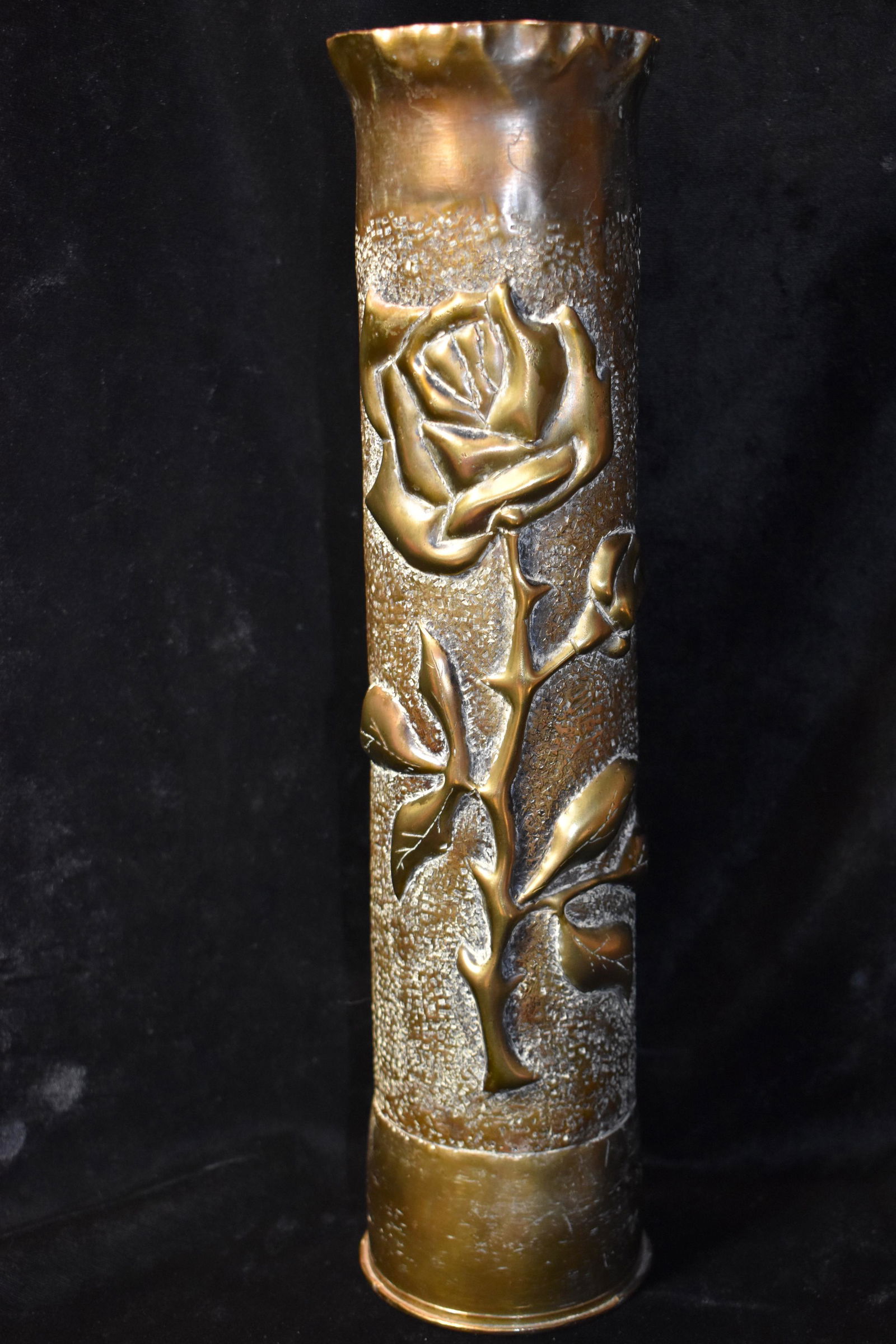 STUNNING 1917 ROSE 75 MM TRENCH ART ARTILLERY SHELL: 1917 ROSE 75 MM TRENCH ART ARTILLERY SHELL CASING. The artistry on this piece is outstanding. It depicts a single rose deeply embossed out from the metal. The bottom of the shell reads 75 DEC 1334 17.