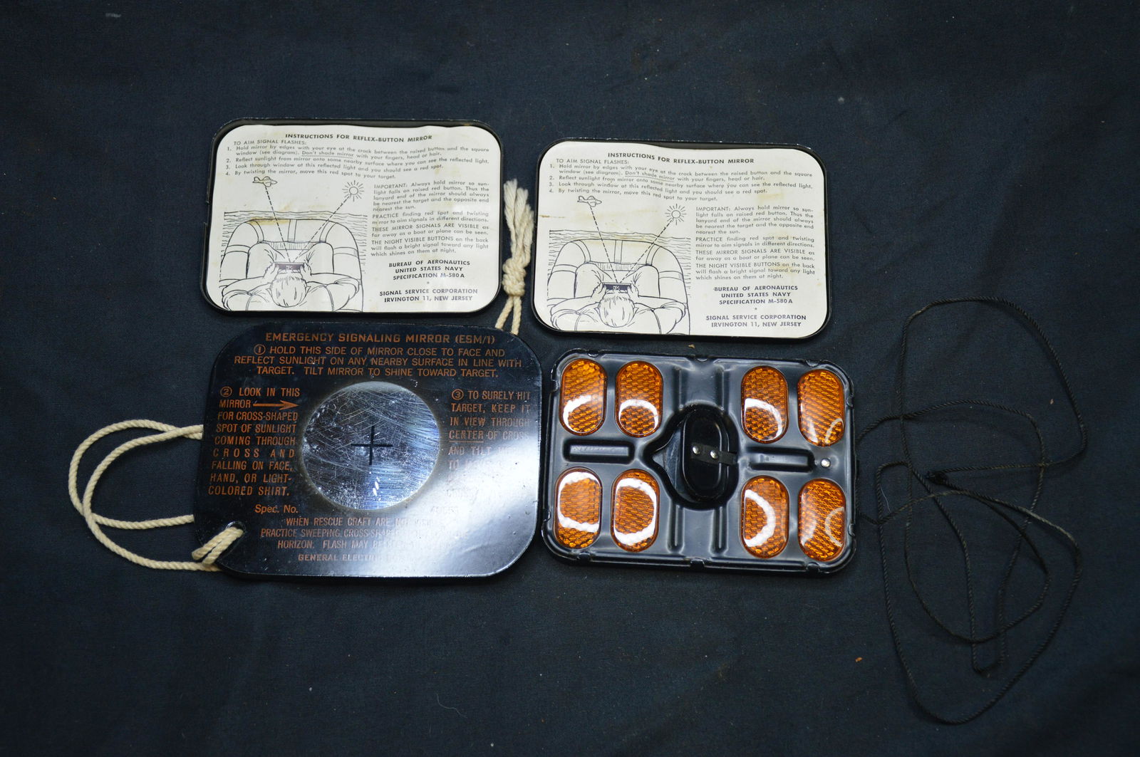 2 emergency signaling mirrors: One is made by General Electric Company Spec. No. 40653. The other is made by The Bureau of Aeronautics United States Navy specification M -580A.