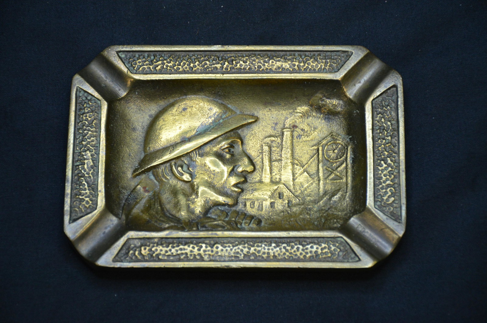 France Ash Tray WW2: Heavy Brass ash tray with a closeup picture of a soldier standing in front of a factory during WW2. Inscribed on the back is France 1945 Depose.
