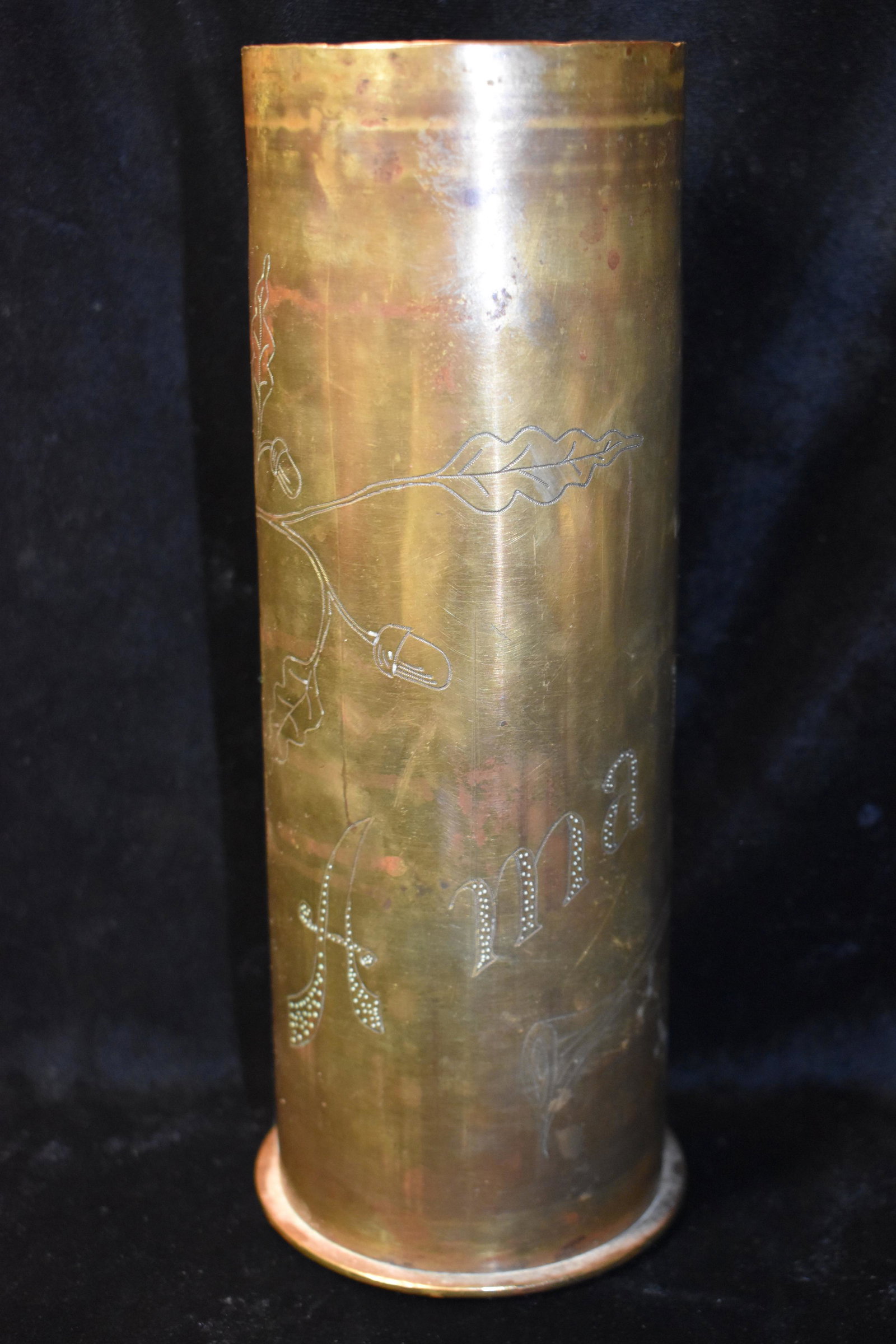 1917 WW1 A Ma Mere 75 MM Trench Art German Casing: 1917 WW1 A Ma Mere 75 MM Trench Art German Casing. This casing reads "A MA MERE" which translates to My Mother. It is adorned with Acron Limbs and Acorns. This one has a fair amount of age spots to it