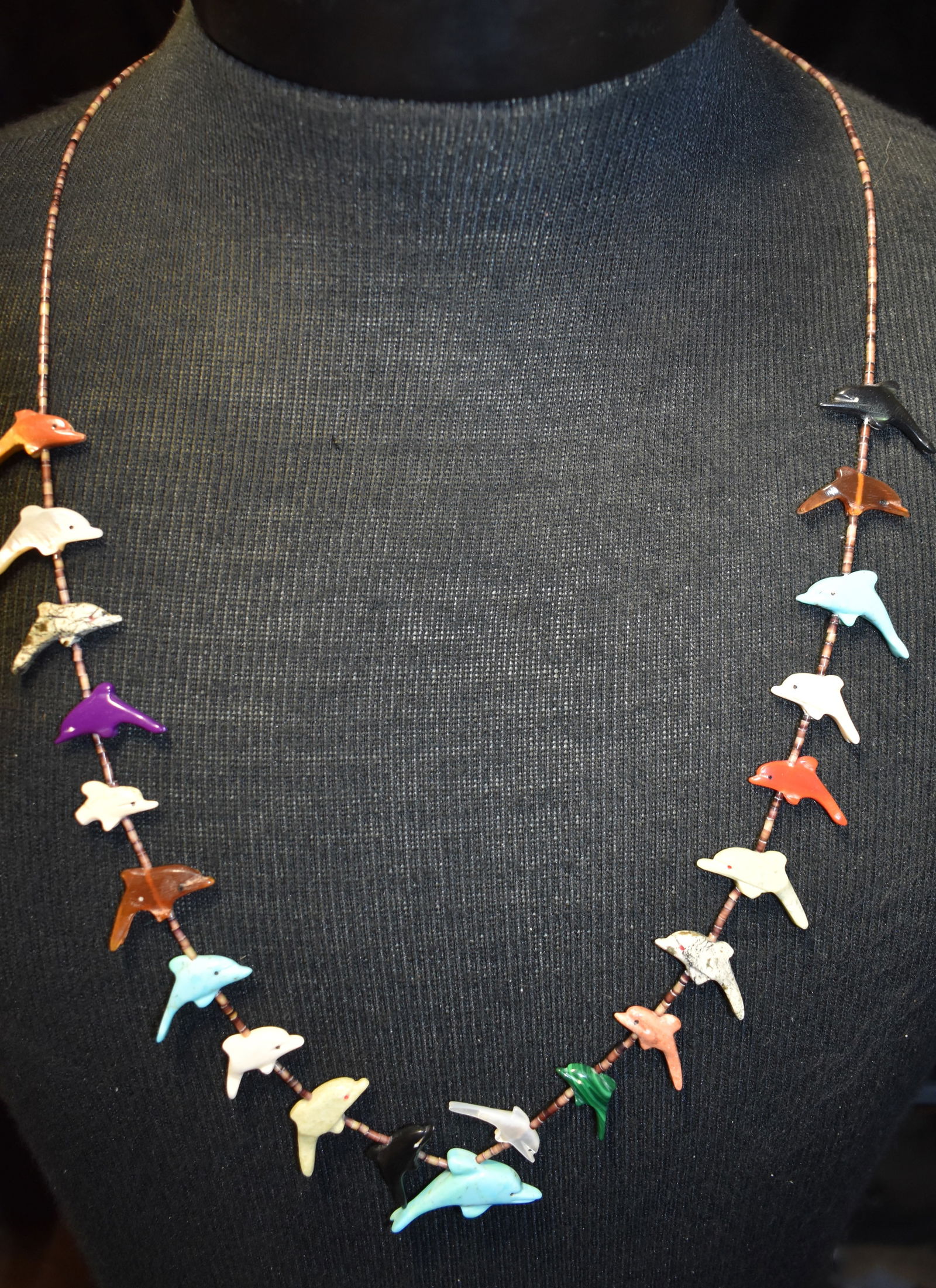 Zuni/Navajo Fetish Necklace from the 1990s: Zuni/Navajo Fetish Necklace from the 1990s. It has traditional shell heishe, with a less conventional subject dolphins hand carved from turquoise, malachite, catlinite, mother of pearl, and sugilite.