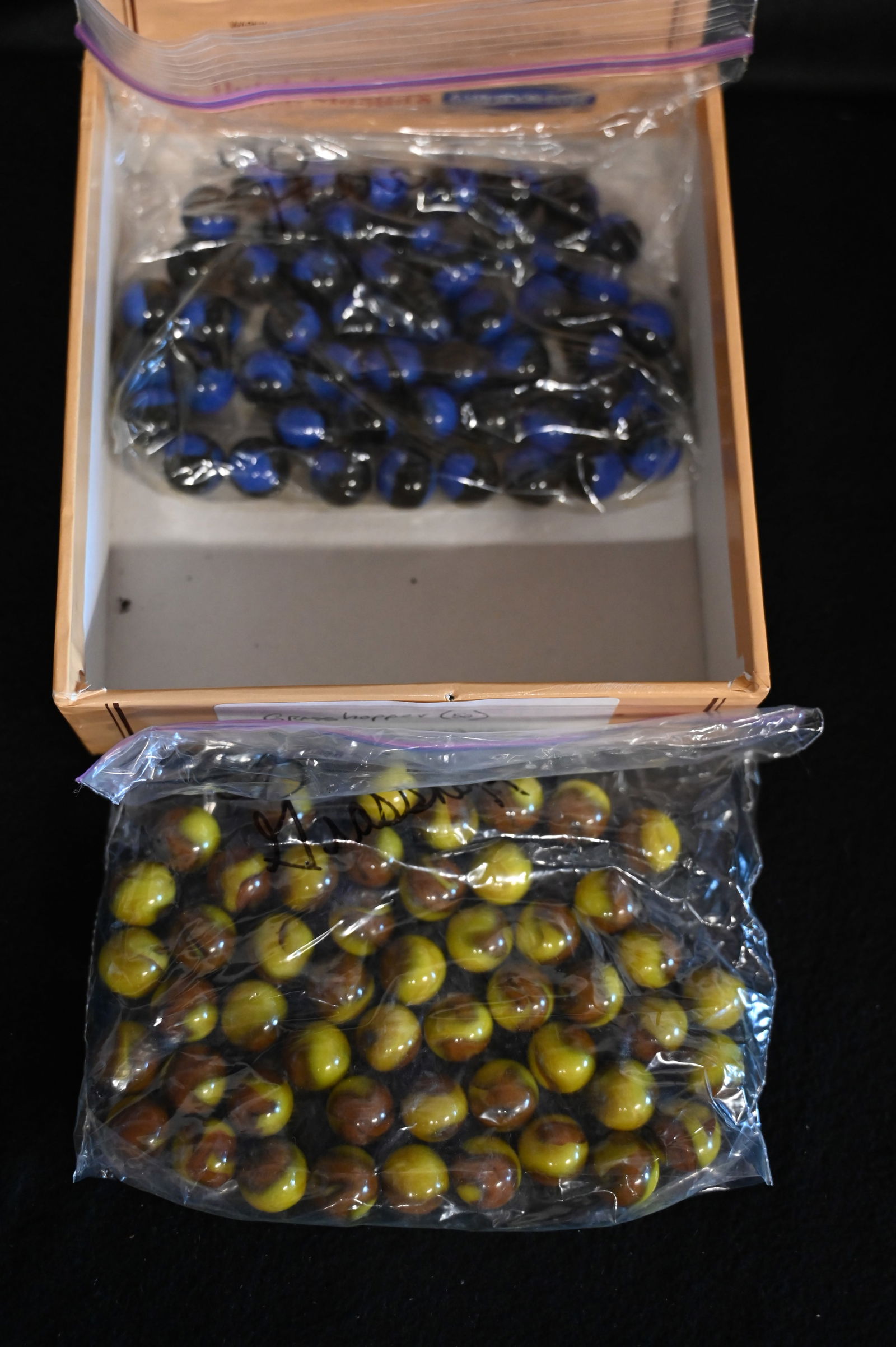 50 Grasshopper Marbles and 50 Hercules Marbles in a Dutch Masters Cigar Box. The size of the: 50 Grasshopper Marbles and 50 Hercules Marbles in a Dutch Masters Cigar Box. The size of the marbles is 5/8".