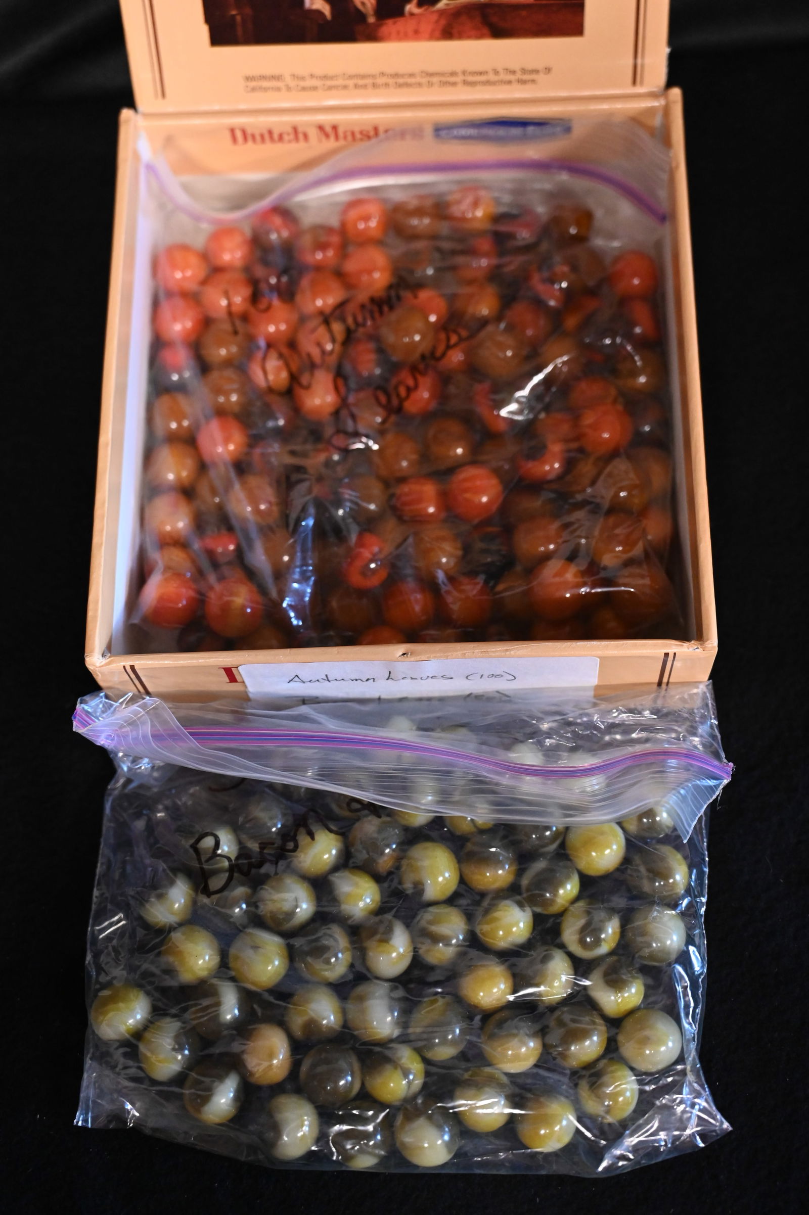 100 Autumn Leaves Marbles and 50 Bacon & Eggs Marbles in a Dutch Masters Cigar Box. The size of the: 100 Autumn Leaves Marbles and 50 Bacon & Eggs Marbles in a Dutch Masters Cigar Box. The size of the marbles is 5/8".