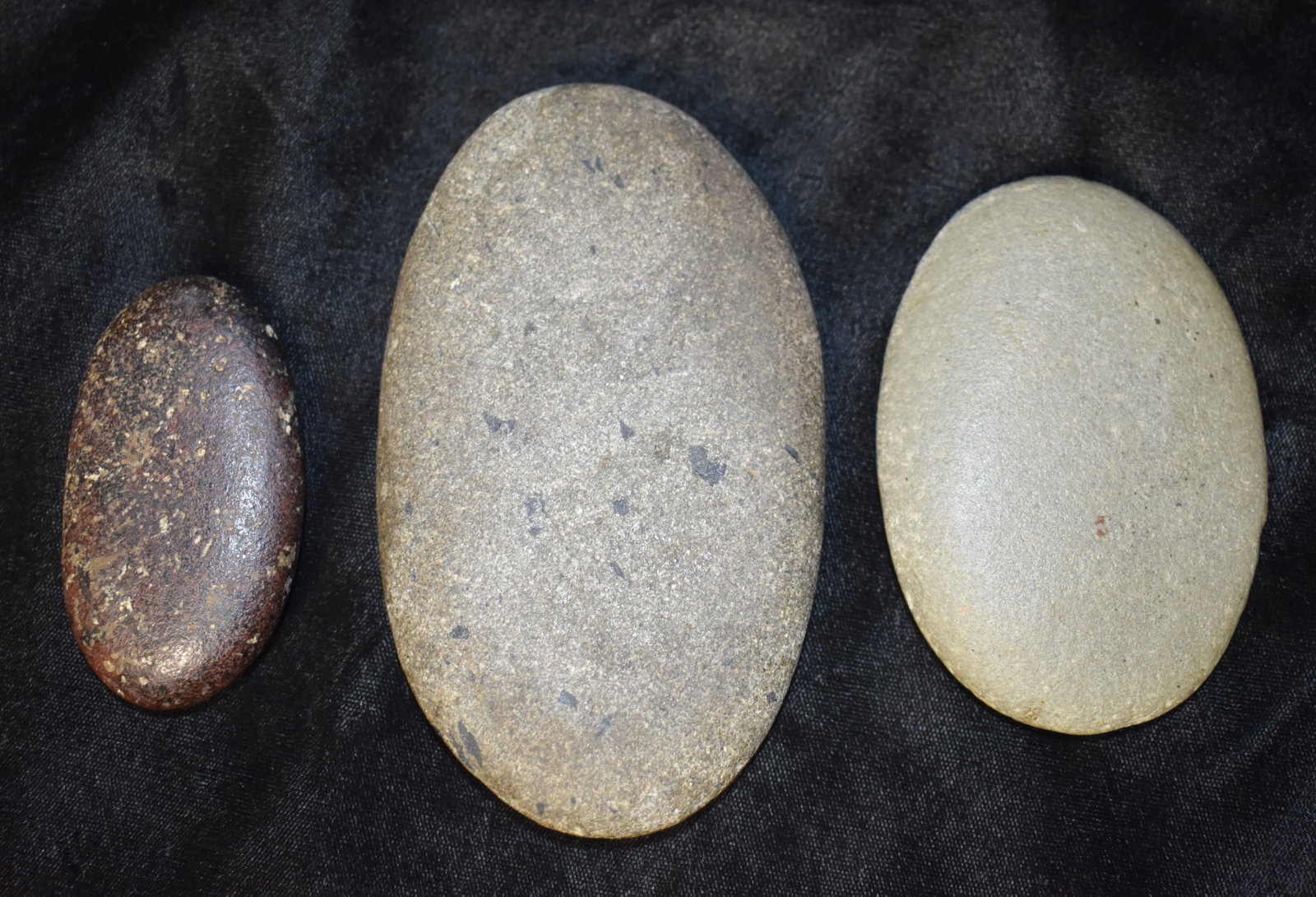 3 Heavily Used Granite Oval Camp Stones found in Pettis County, Missouri: 3 Heavily Used Granite Oval Camp Stones. Nice examples of their type these stones were likely used for abrasion, cracking nuts or making powders in a mortar. They measure 2 7/8" to 5". Ex George Wolf 