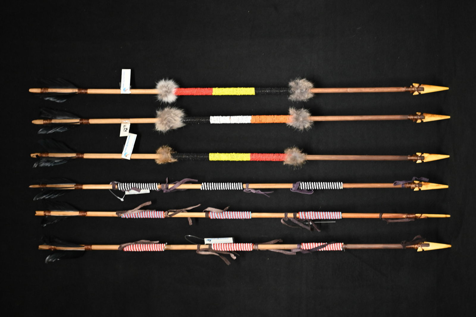 6 Hand Made Wood 34" Wood Arrows. Bone arrow points attached with sinew to the wood shaft that is: 6 Hand Made Wood 34" Wood Arrows. Bone arrow points attached with sinew to the wood shaft that is decorated with beadwork. The crow feather fletching is attached with sinew and some have rabbit fur fo