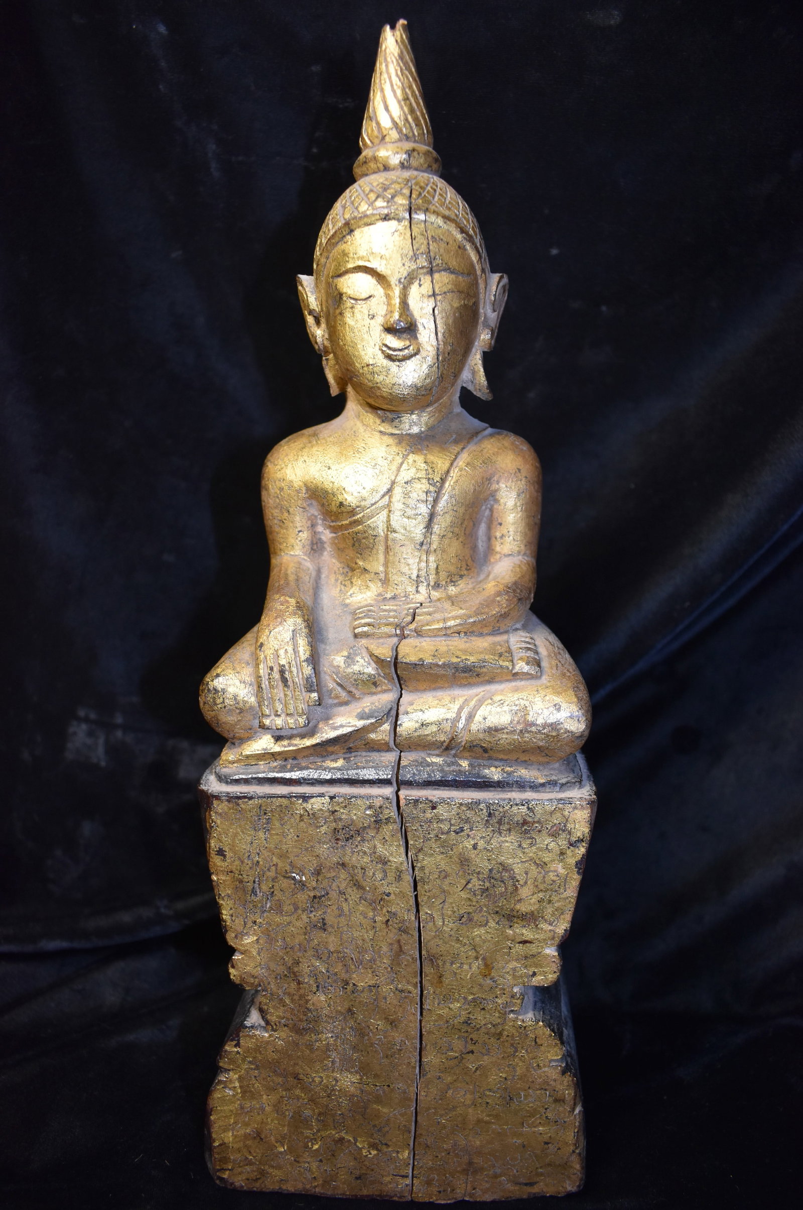15 1/4" Very Old Thai Carved Wood & Gold Gilt Buddha 19th Century: 15 1/4" Very Old Thai Carved Wood & Gold Gilt Buddha. Hand Carved from one solid piece of wood. Nice restoration candidate. Missing a little off the top of his hat, part of one earring and has a wood 