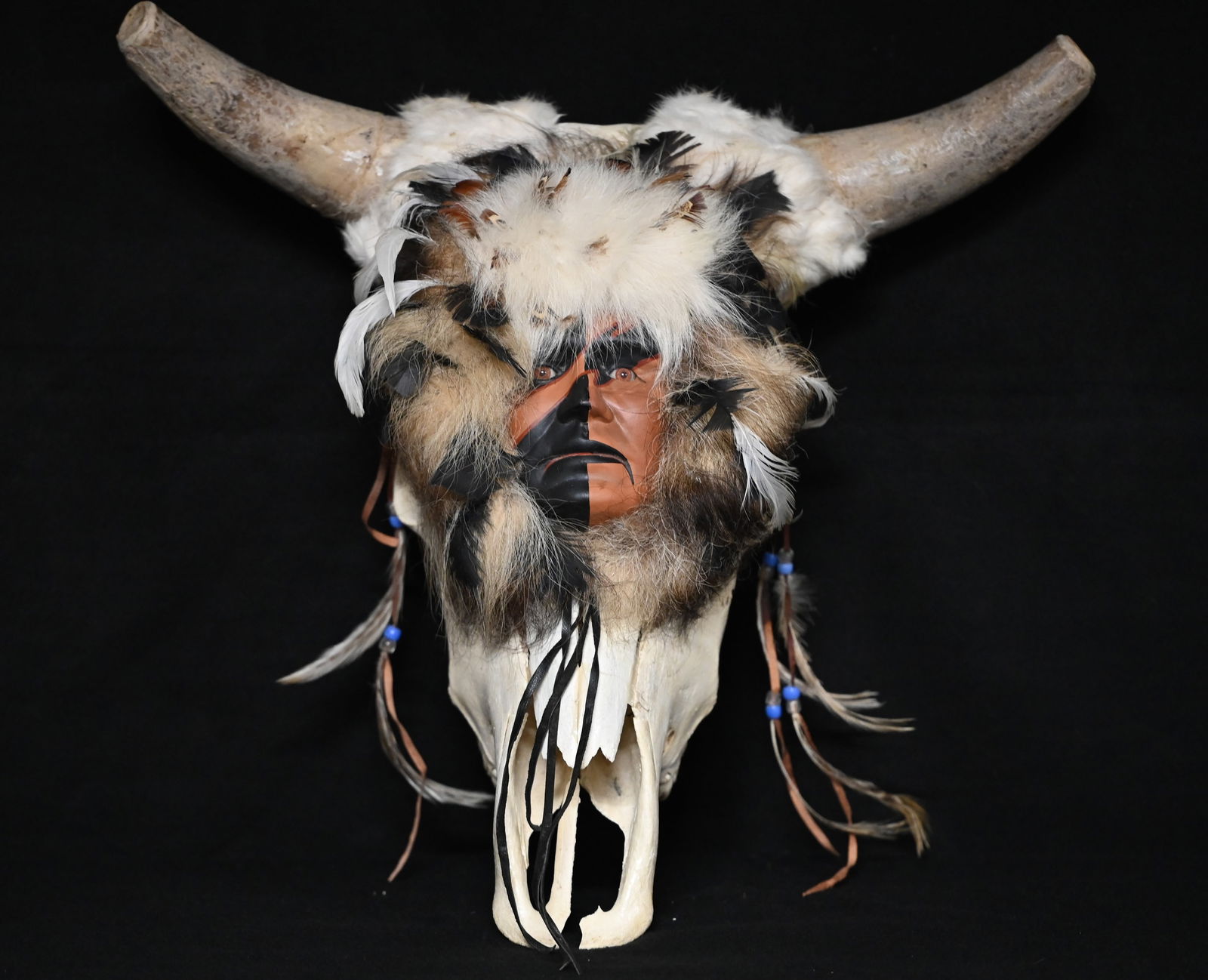 Cow Skull With a Hand Painted Apache Warrior Face decorated with Fur, Feathers, and beaded drops. (1 of 5)