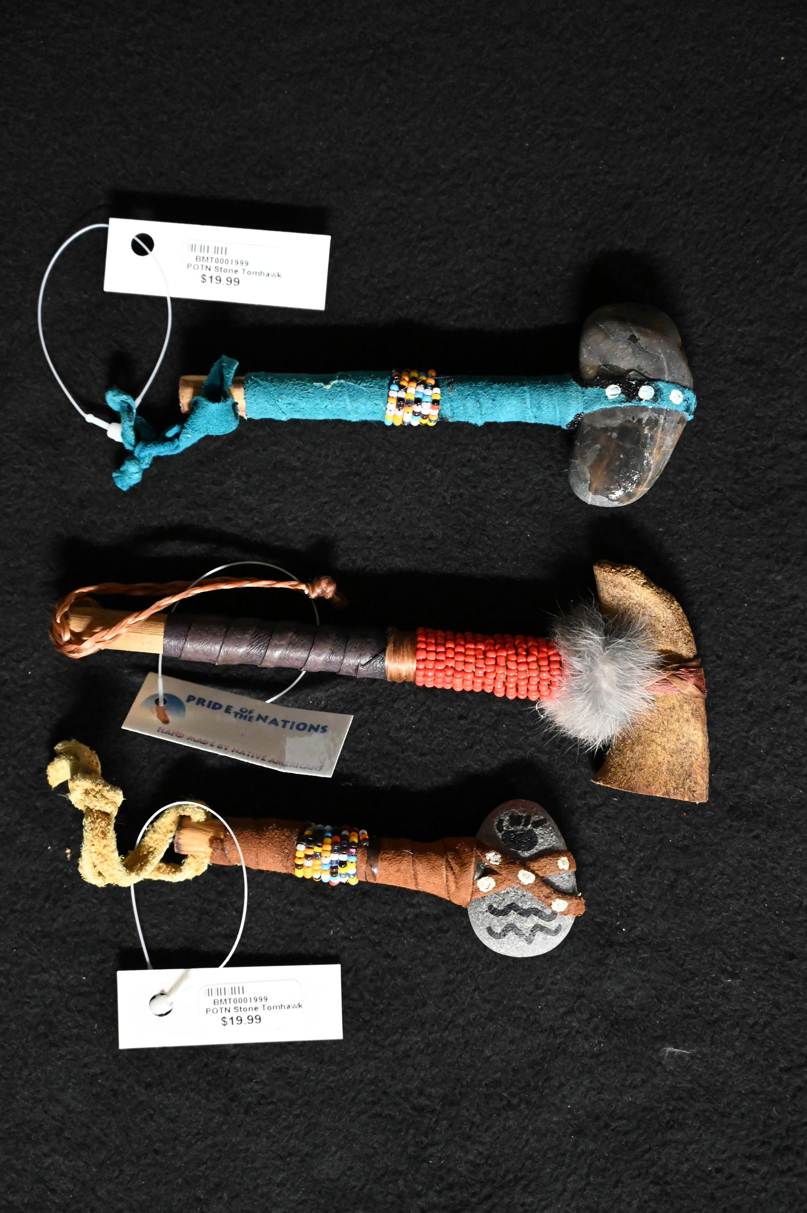 2 Stone 1 Bone Tomahawks with Beaded and Leather Wrapped Wood Handles. Longest is 6 1/4 inches: 2 Stone 1 Bone Tomahawks with Beaded and Leather Wrapped Wood Handles. Longest is 6 1/4 inches long. Ex: Pride of The Nations Store. The Store represented many of the tribes artwork from across the co