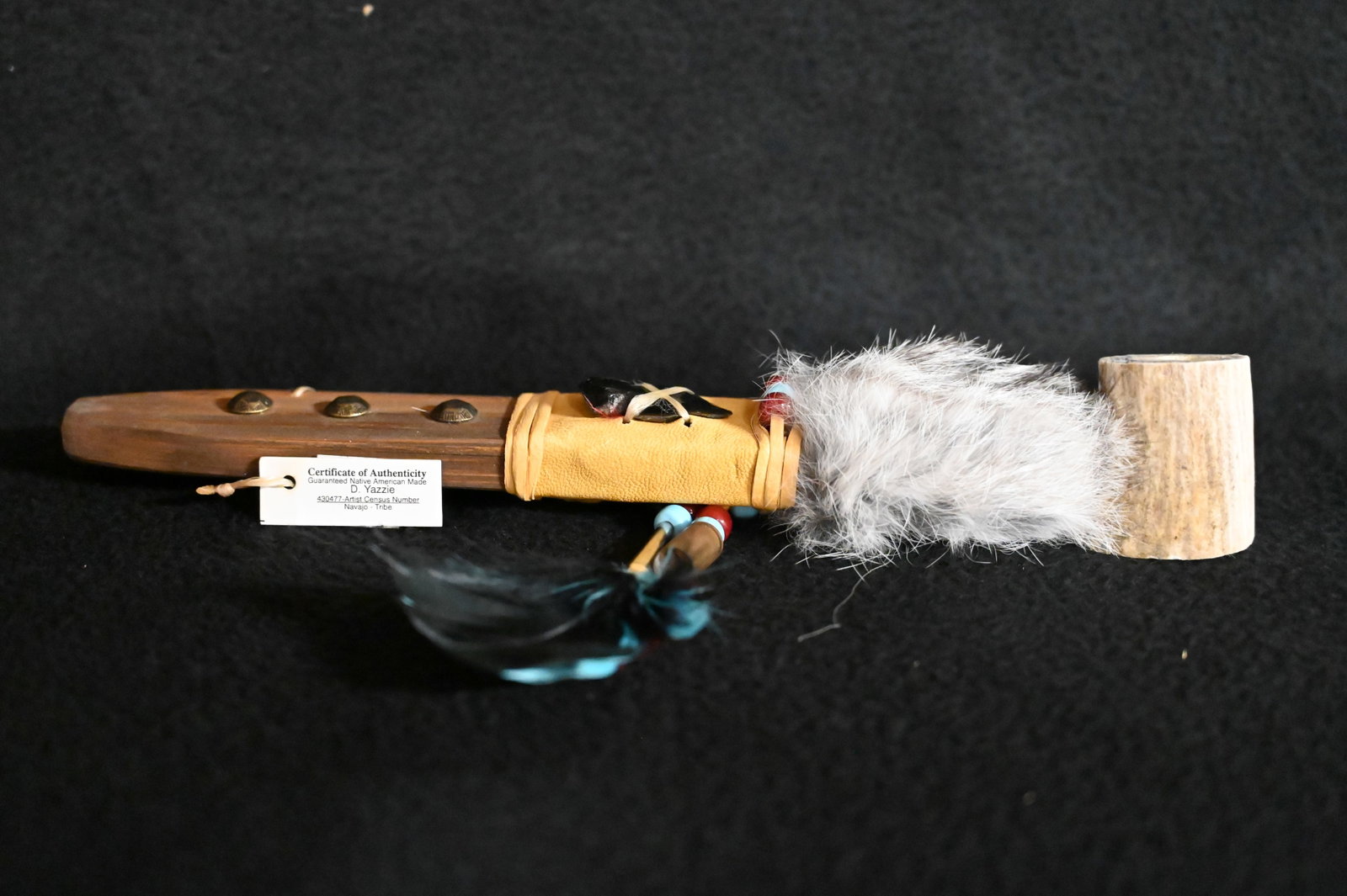 11" Navajo Personal Pipe Made By D. Yazzie of The Navajo Tribe. Deer Antler Bowl with Leather and: 11" Navajo Personal Pipe Made By D. Yazzie of The Navajo Tribe. Deer Antler Bowl with Leather and Rabbit Fur Wrapped Wood Stem that has a Feather drop and an Arrowhead with brass tacks for decoration 