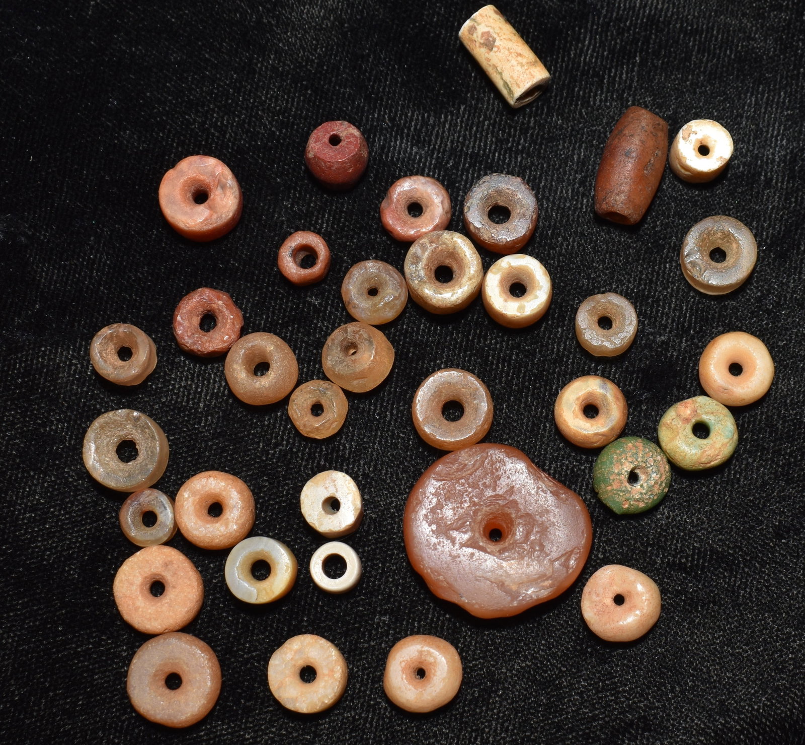 Lot of 30 Neolithic Stone Beads from Africa: Lot of 30 Neolithic Stone Beads from Africa. Nice grouping of ancient beads made of mostly quartz and quartzite. The green one in the group is Amazonite. They measure from 1/4" to 7/8" approximately.