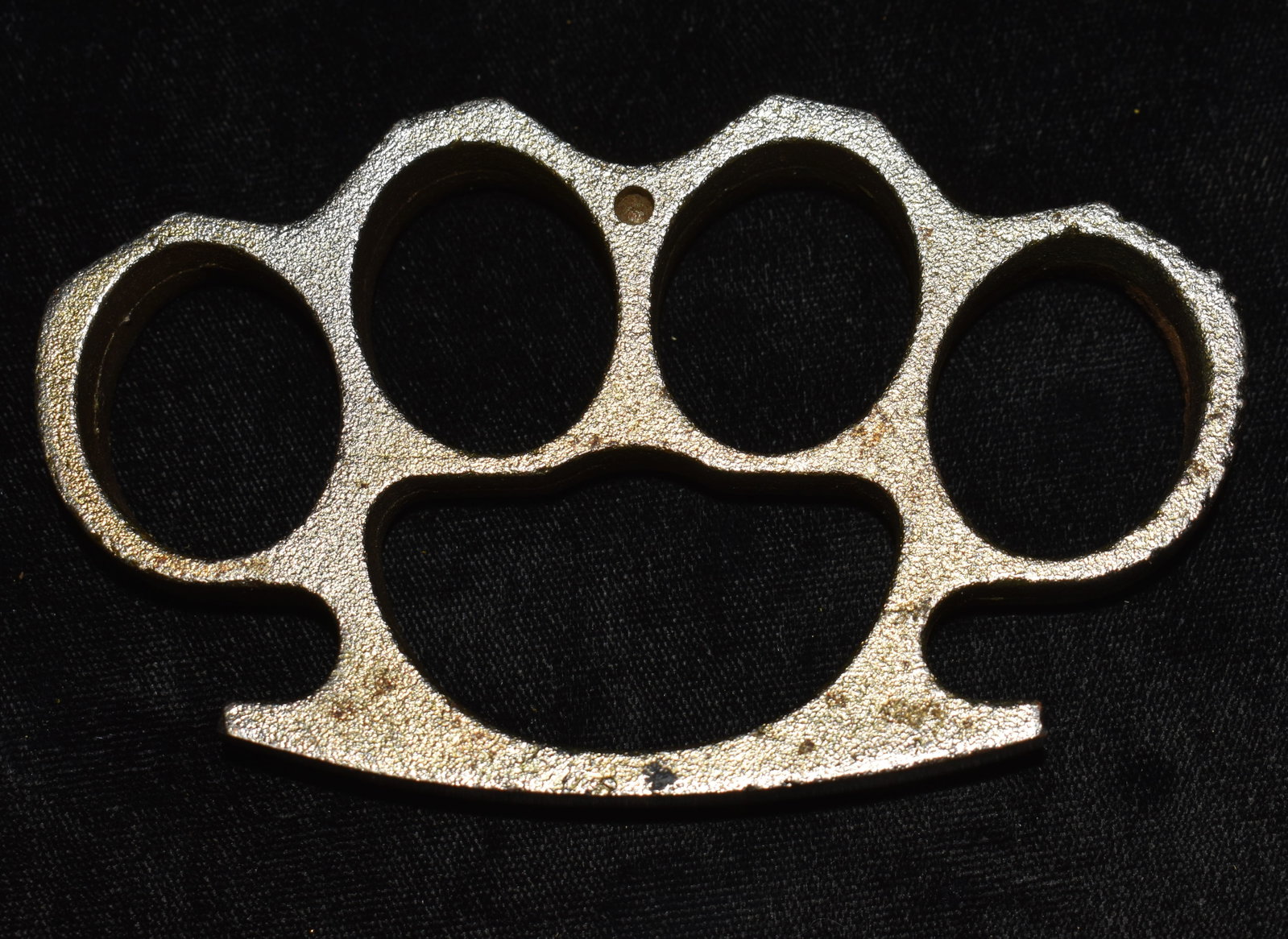 Vintage Brass Knuckles: Vintage Brass Knuckles. These are always referred to as Brass Knuckles but this one is not made of brass. Made of a magnetic metal. Surface has some rust spots. Measures 4 1/2" by 2 5/8" by 1/2"