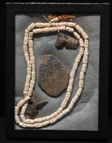 69 Japanese Hand Carved Antler Prayer Skull Beads and Damaged Arrowheads and Pottery in a frame.