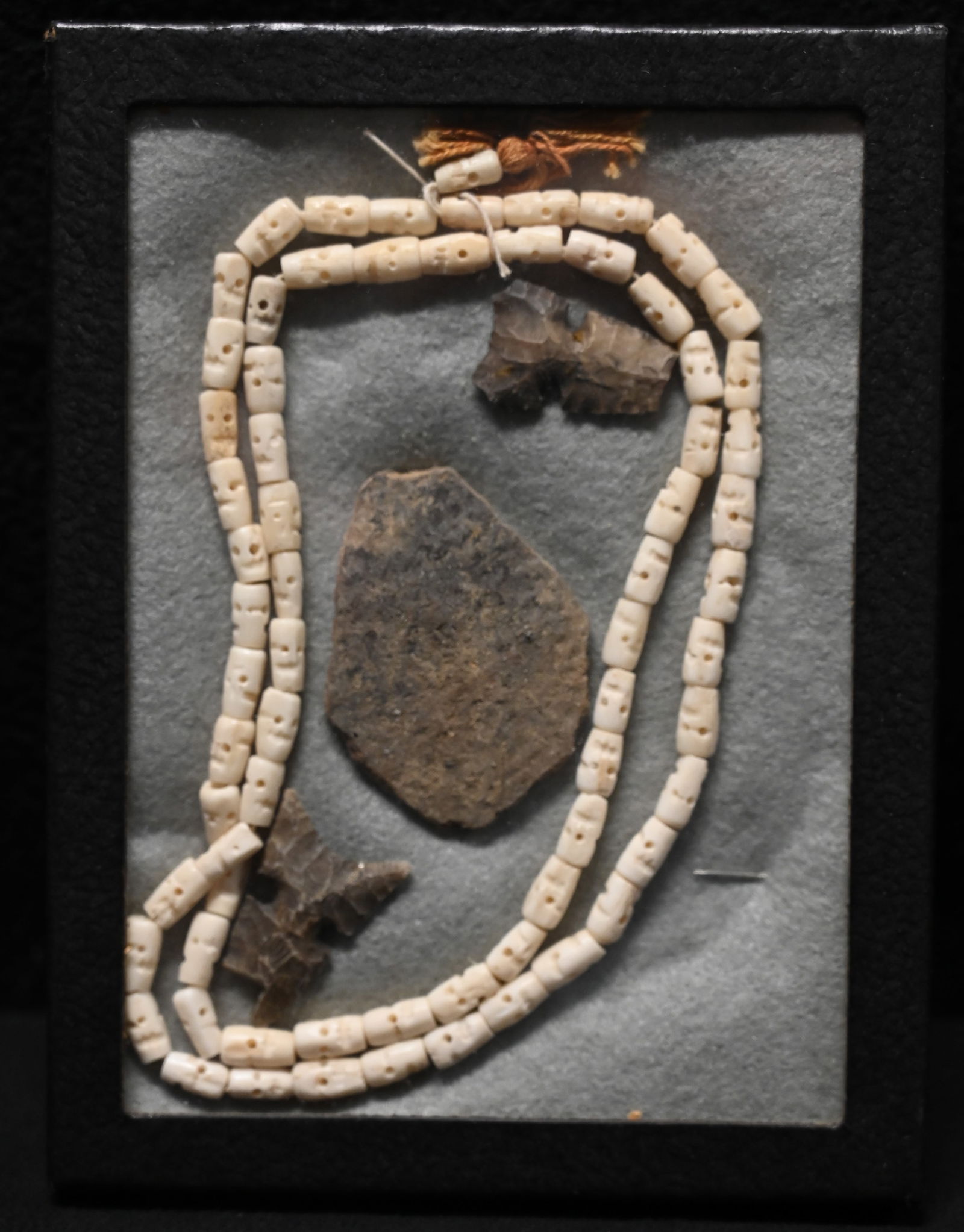 69 Japanese Hand Carved Antler Prayer Skull Beads and Damaged Arrowheads and Pottery in a frame. (1 of 7)
