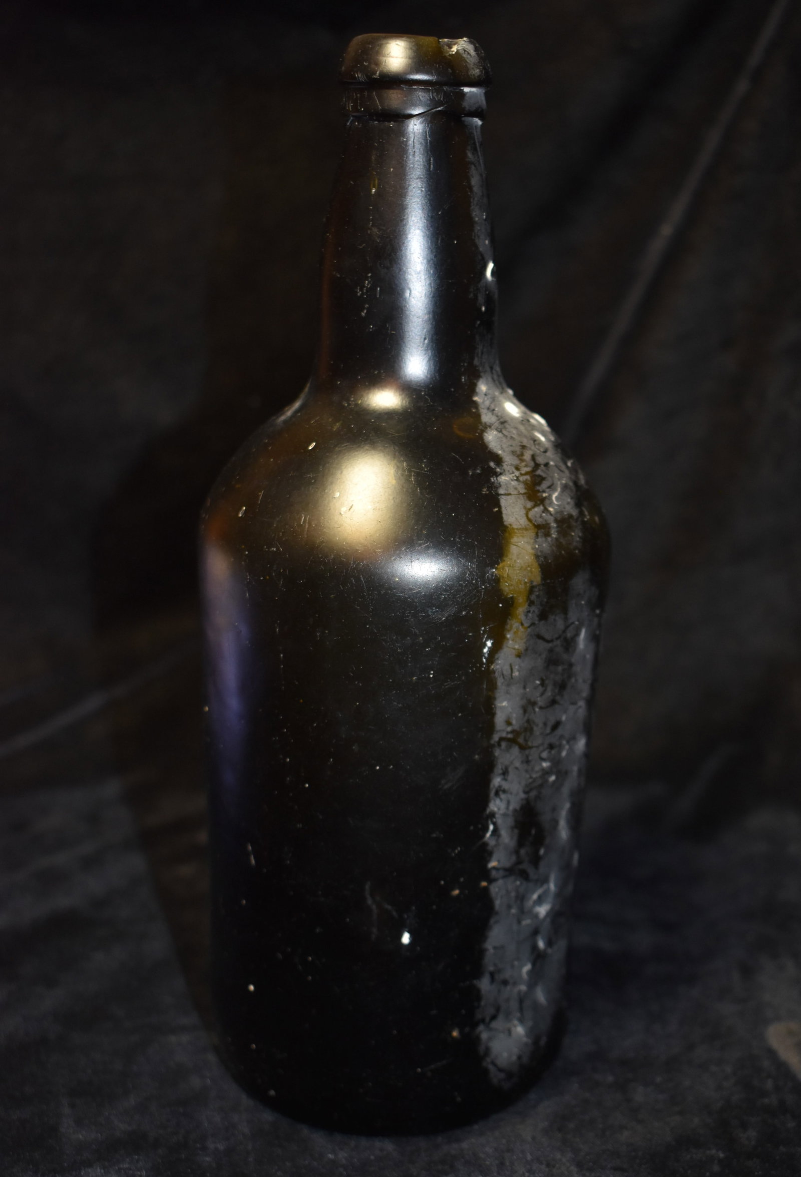Early 1700's British Black Pirate Bottle: Early 1700's British Black Pirate Bottle. This color was used due to the high tax rates in England on clear glass at the time. Has a chip on the rim otherwise excellent condition. All original with no