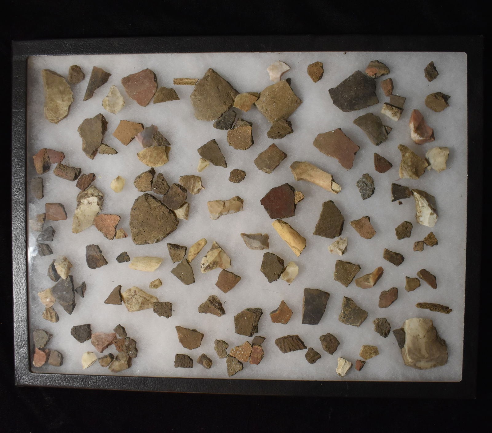 Frame of Pottery Shards, Bone Fragments and Chert Found near Cahokia Mounds, Illinois: Frame of Pottery Shards, Bone Fragments and Chert Found near Cahokia Mounds, Illinois by Kristie Schwab. Largest fragment is approximately 2". Frame measures 16 1/4" by 12 1/4".