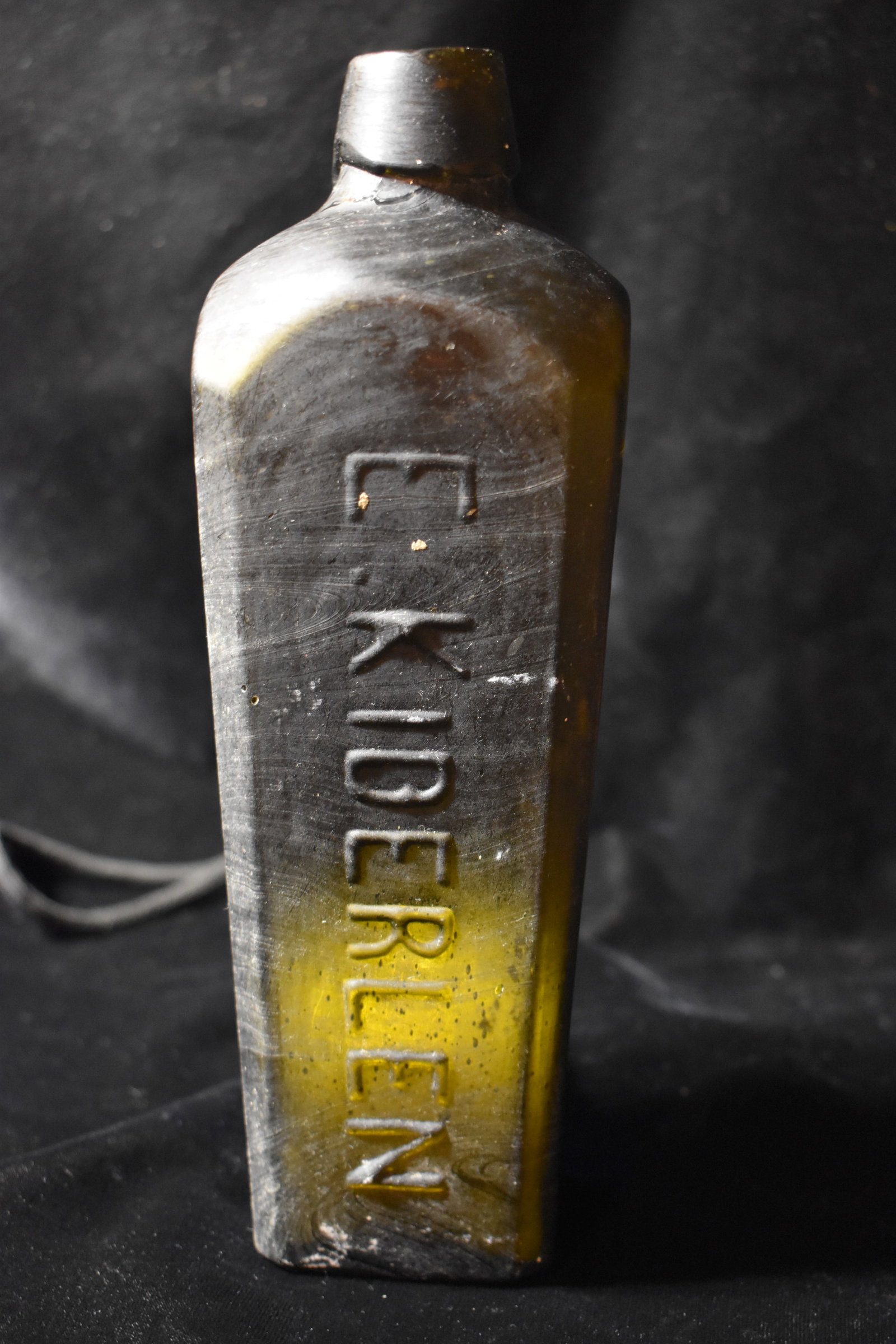 Mid 1800's Gin Bottle E. Kiderlen: E. Kiderlen gin bottles are known for their distinctive mold-blown glass and embossed branding. These bottles were typically used for transporting Dutch or Rotterdam gin and are prized by collectors f