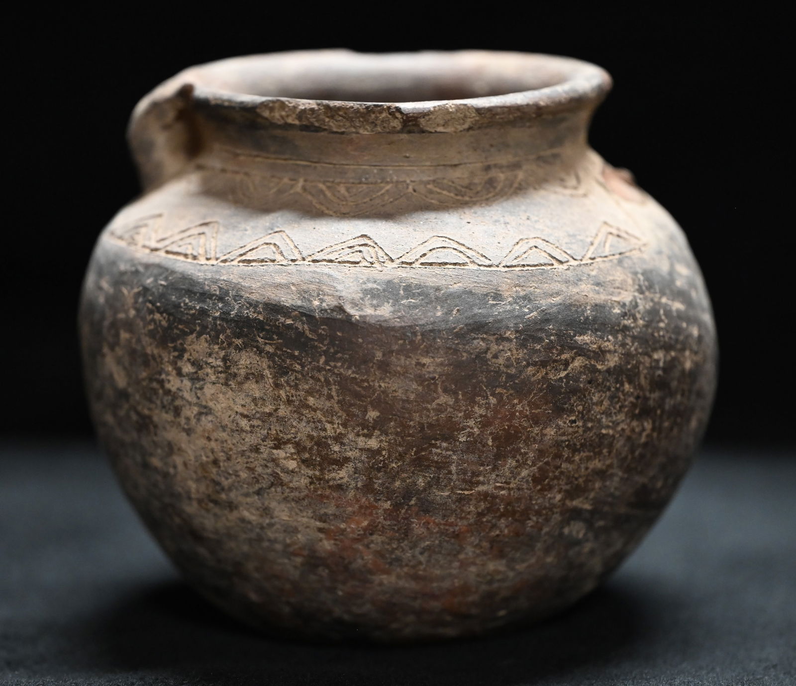 Pre-Columbian Double Strap Handel 5 1/2" Pottery Vessel: Pre-Columbian Double Strap Handel 5 1/2" Pottery Vessel. 1 strap handle is broke and missing. Has etching around the top of the bowl for decoration. Circa 600-1500AD. 6" Wide.